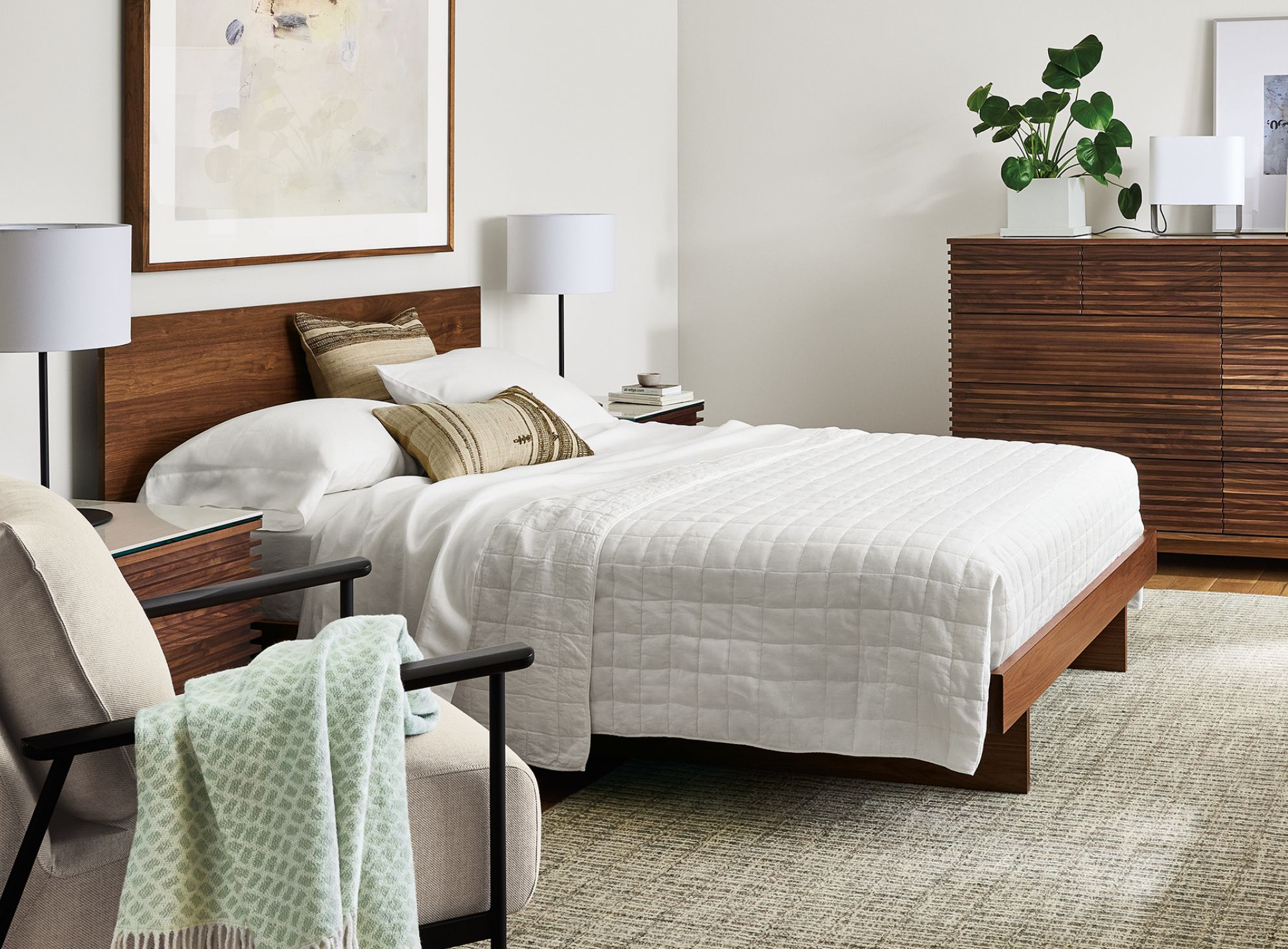 Bedroom with Anton queen bed in walnut and coles ten-drawer dresser in walnut with Nera rug in stone.