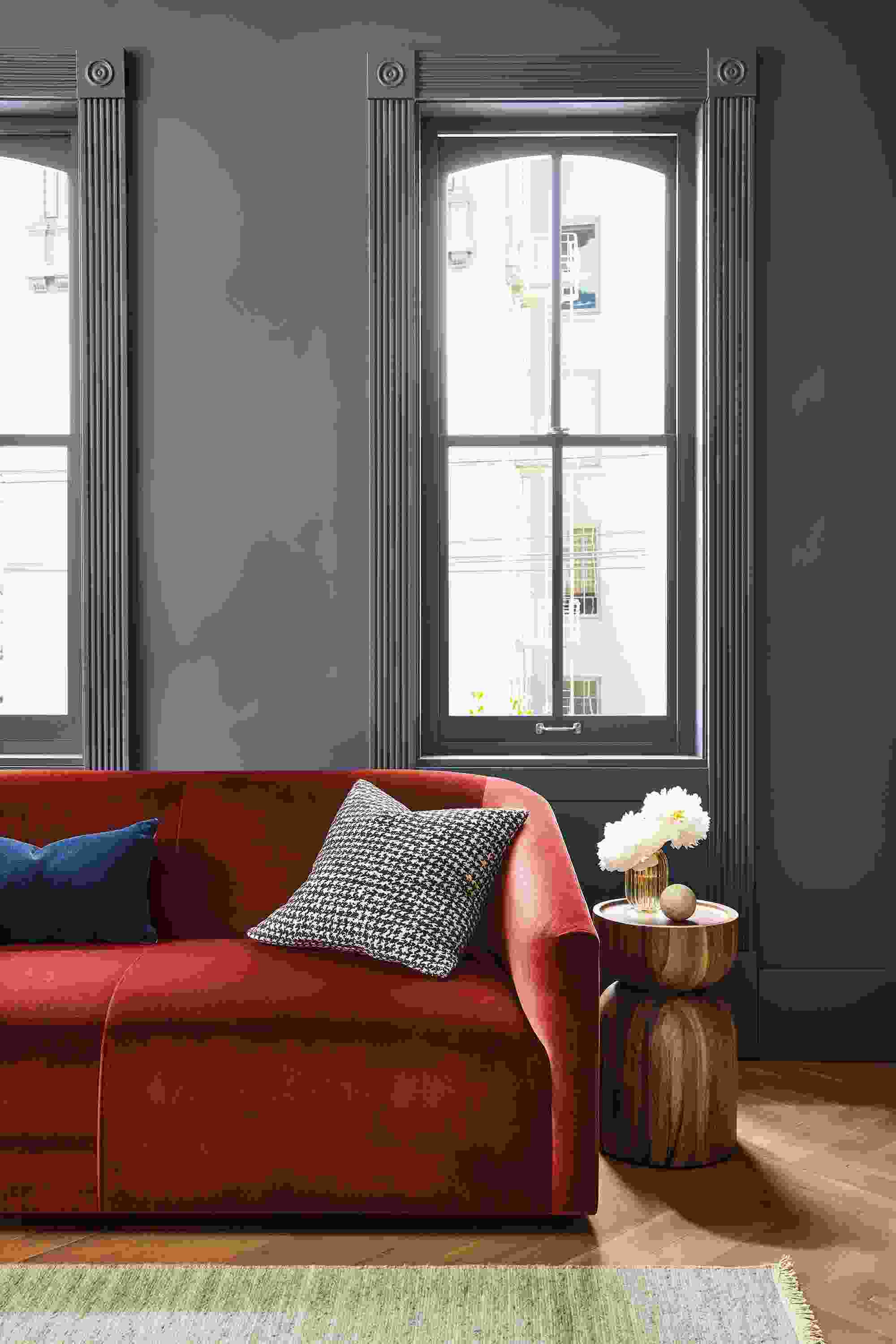Living room with detail of Ada 70-wide sofa in Vance Paprika and Nyla table in Natural Solid Conacaste Wood.