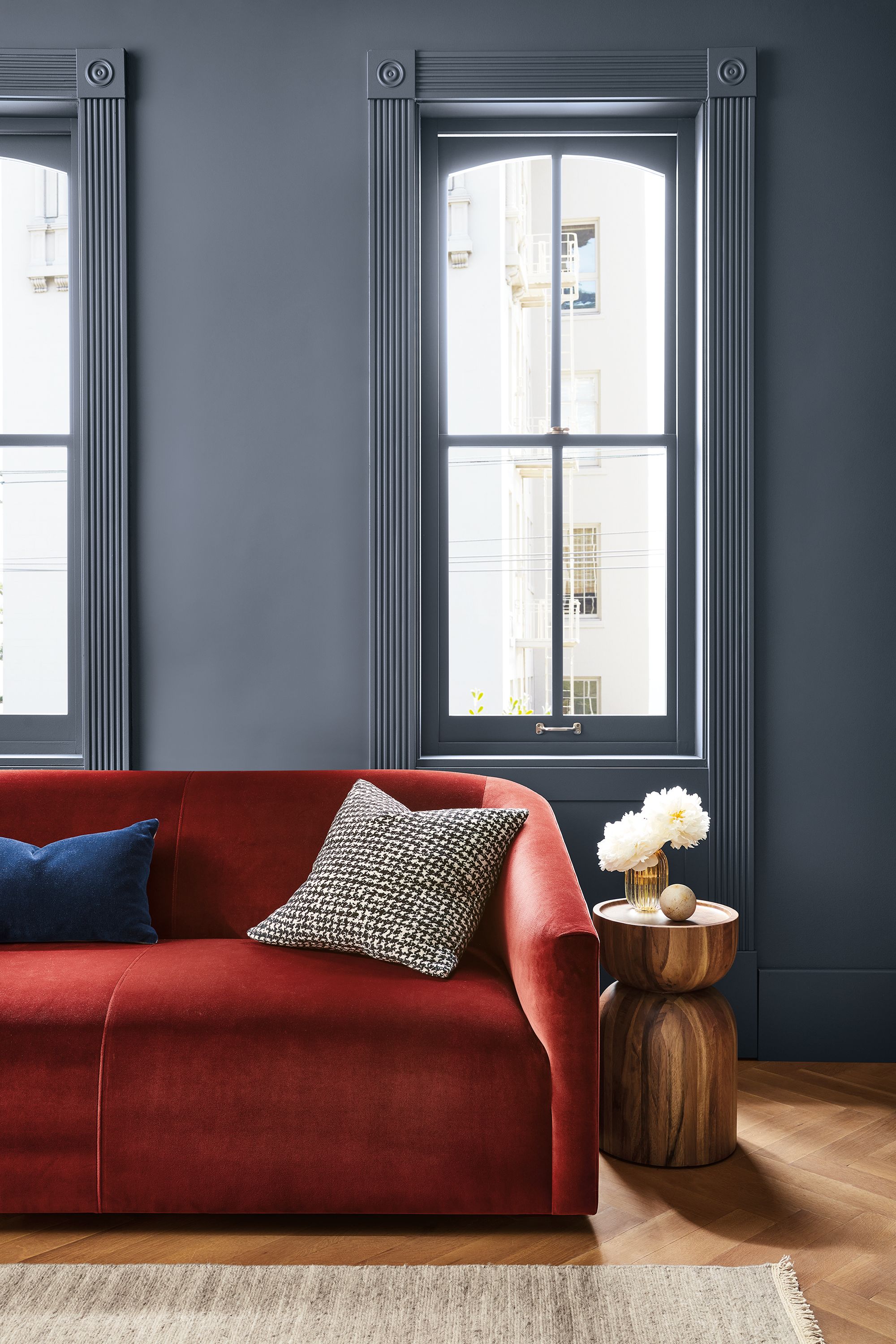 Living room with detail of Ada 70-wide sofa in Vance Paprika and Nyla table in Natural Solid Conacaste Wood.