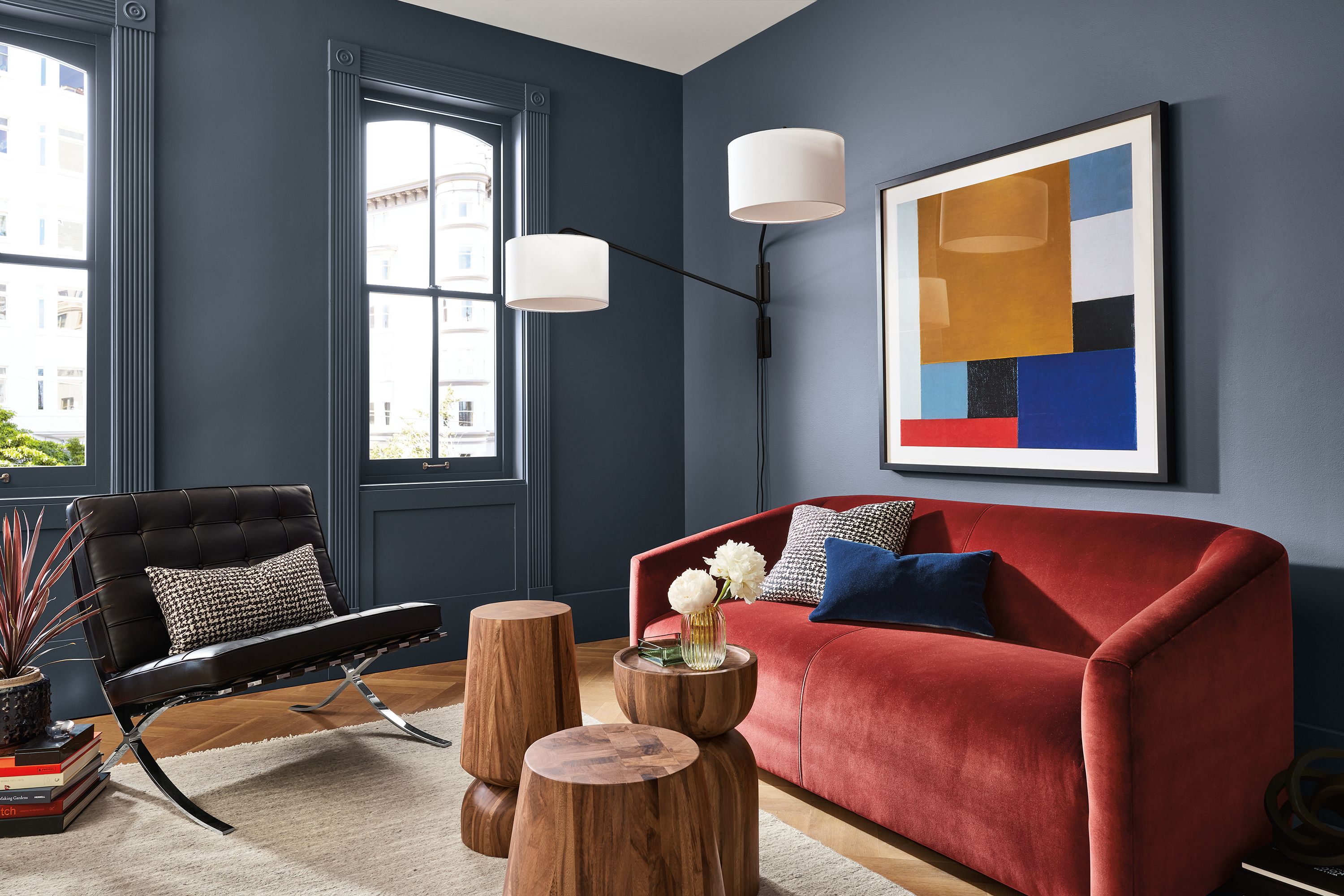 Living room with Ada 70-wide sofa in Vance Paprika and Seville chair in black leather with 3 Nyla side tables in natural Conacaste wood.