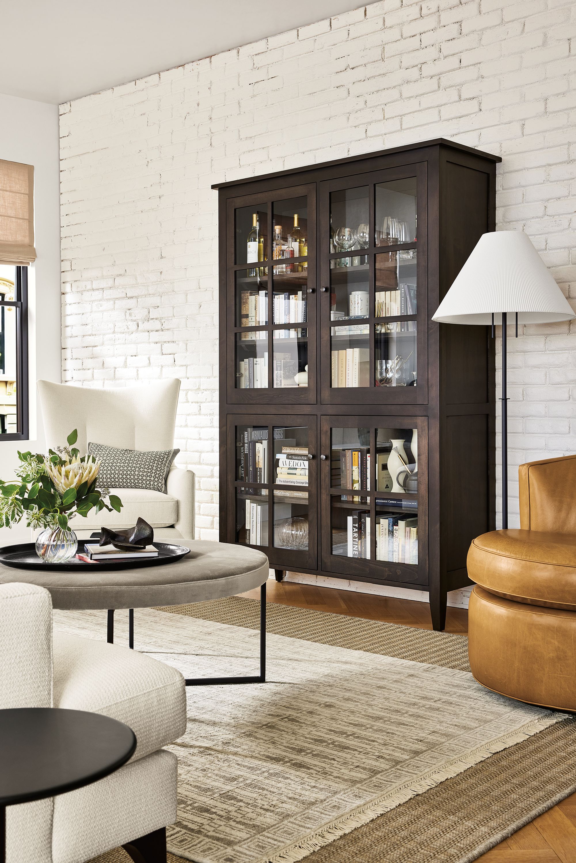 living room with adams storage cabinet in charcoal finish with glass windows.