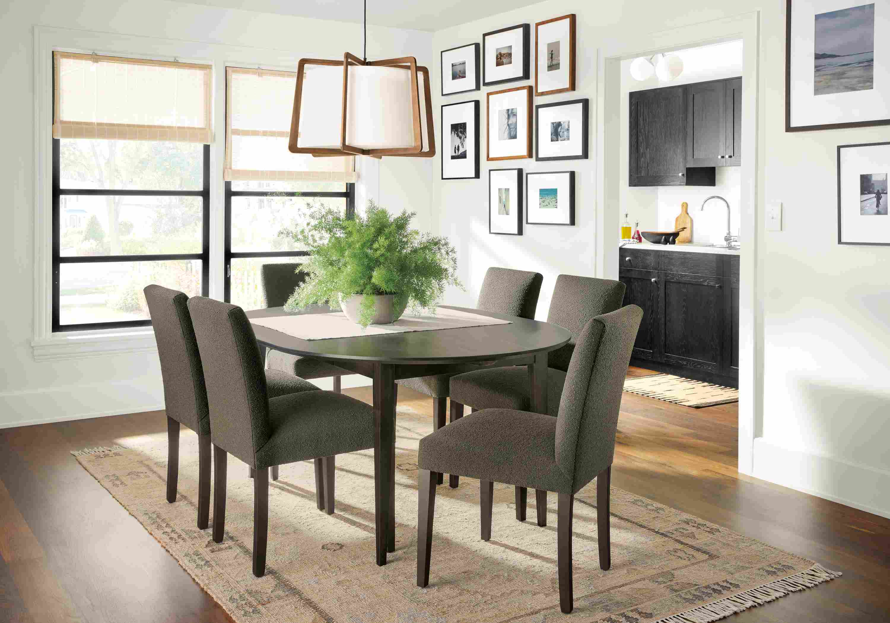 Dining room with Adams round extension table in charcoal on Maple, Peyton chairs in Declan Olive and Villa rug in sand.