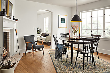 Dining room with Adams 48-inch diameter round extension table in charcoal and Thatcher side chair in charcoal finish.