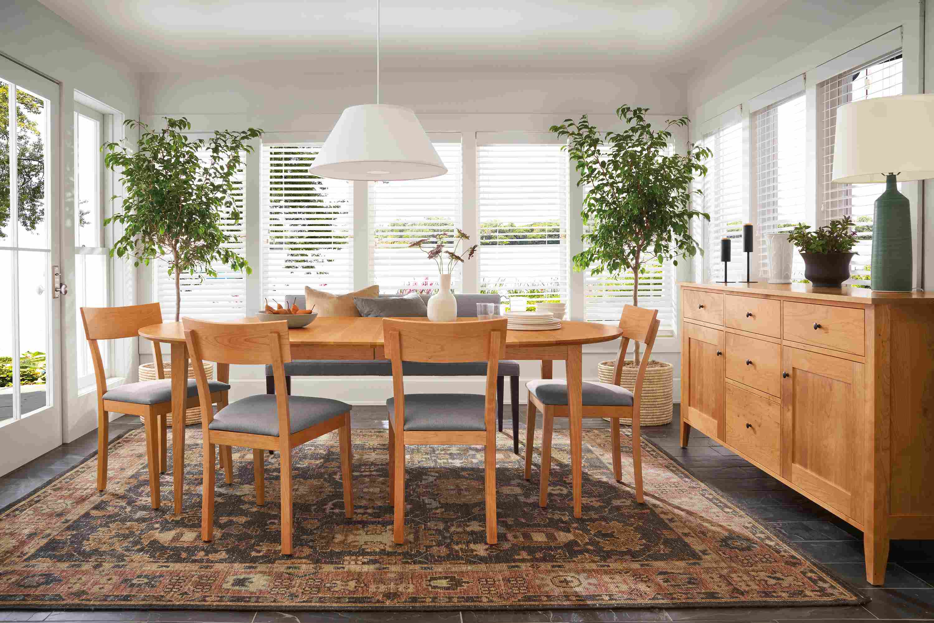 Dining room with Adams extension table and storage cabinet in cherry and Doyle side chairs in cherry with fabric seats.