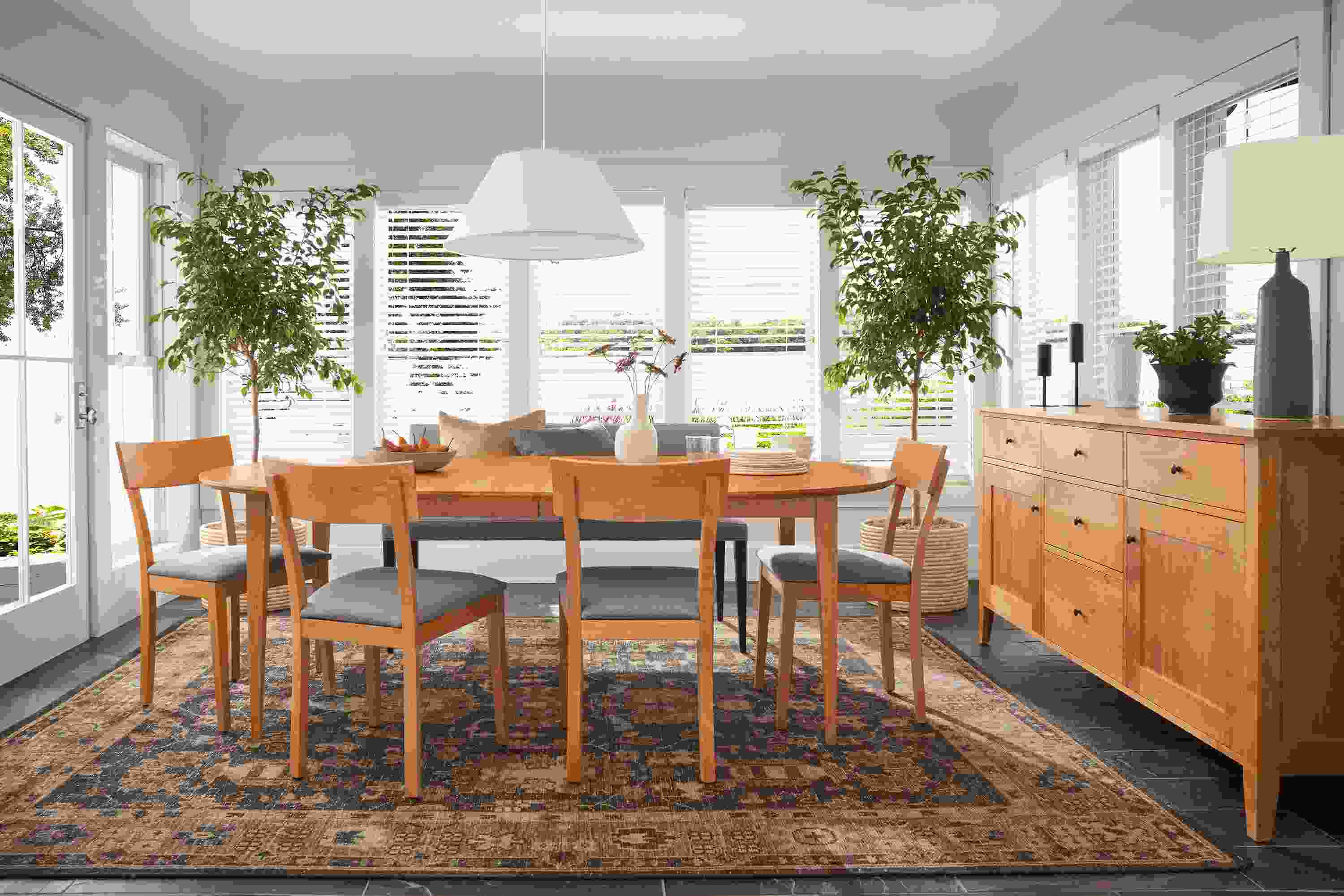 Dining room with Adams extension table and storage cabinet in cherry and Doyle side chairs in cherry with fabric seats.