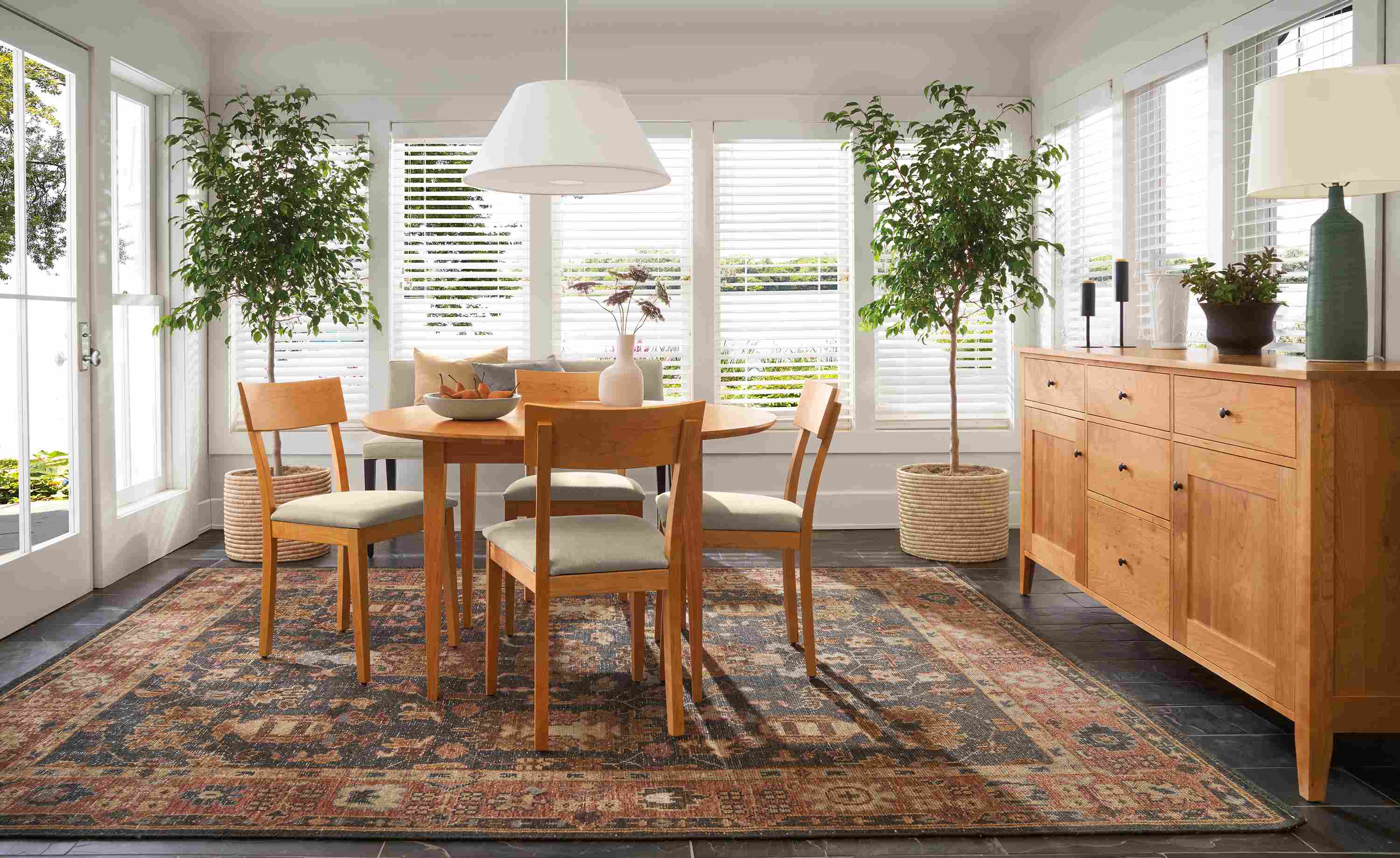 Dining room with adams round extension table in cherry and Doyle side chairs in cherry and Myers Taupe..