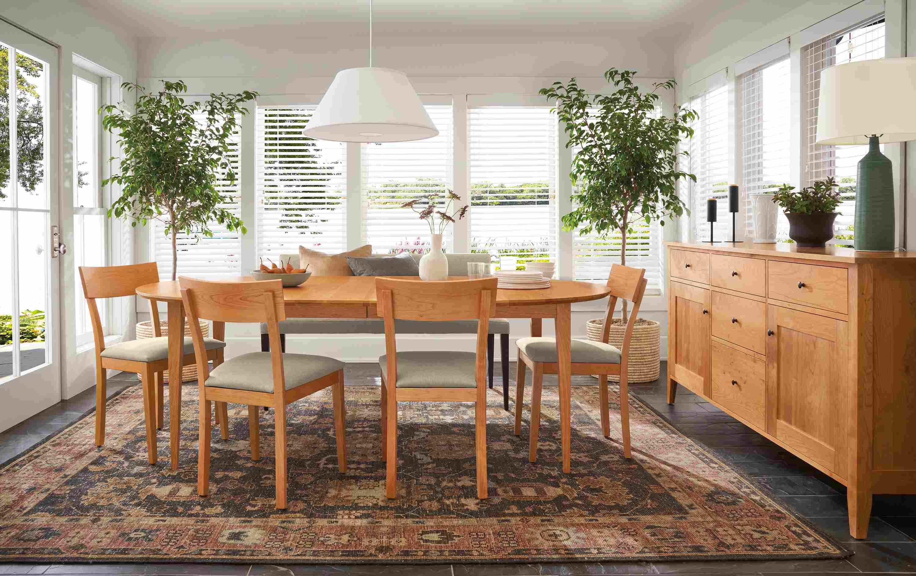 Dining room with adams extension table and storage cabinet in cherry and doyle side chairs in cherry and Myers Taupe.