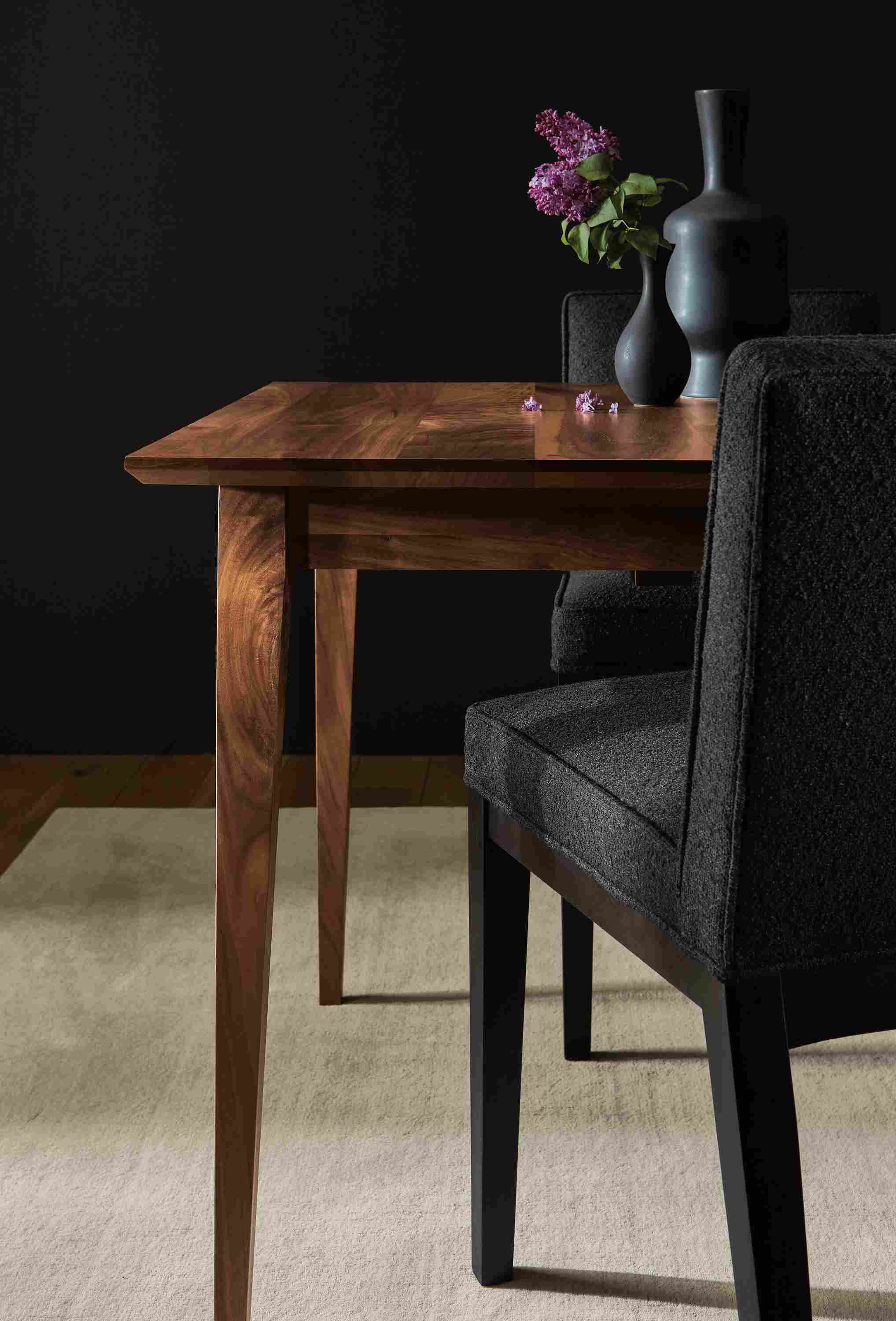 Detail of Adams 60-wide extension table in walnut and 2 Ansel side chairs in Declan Ebony fabric.