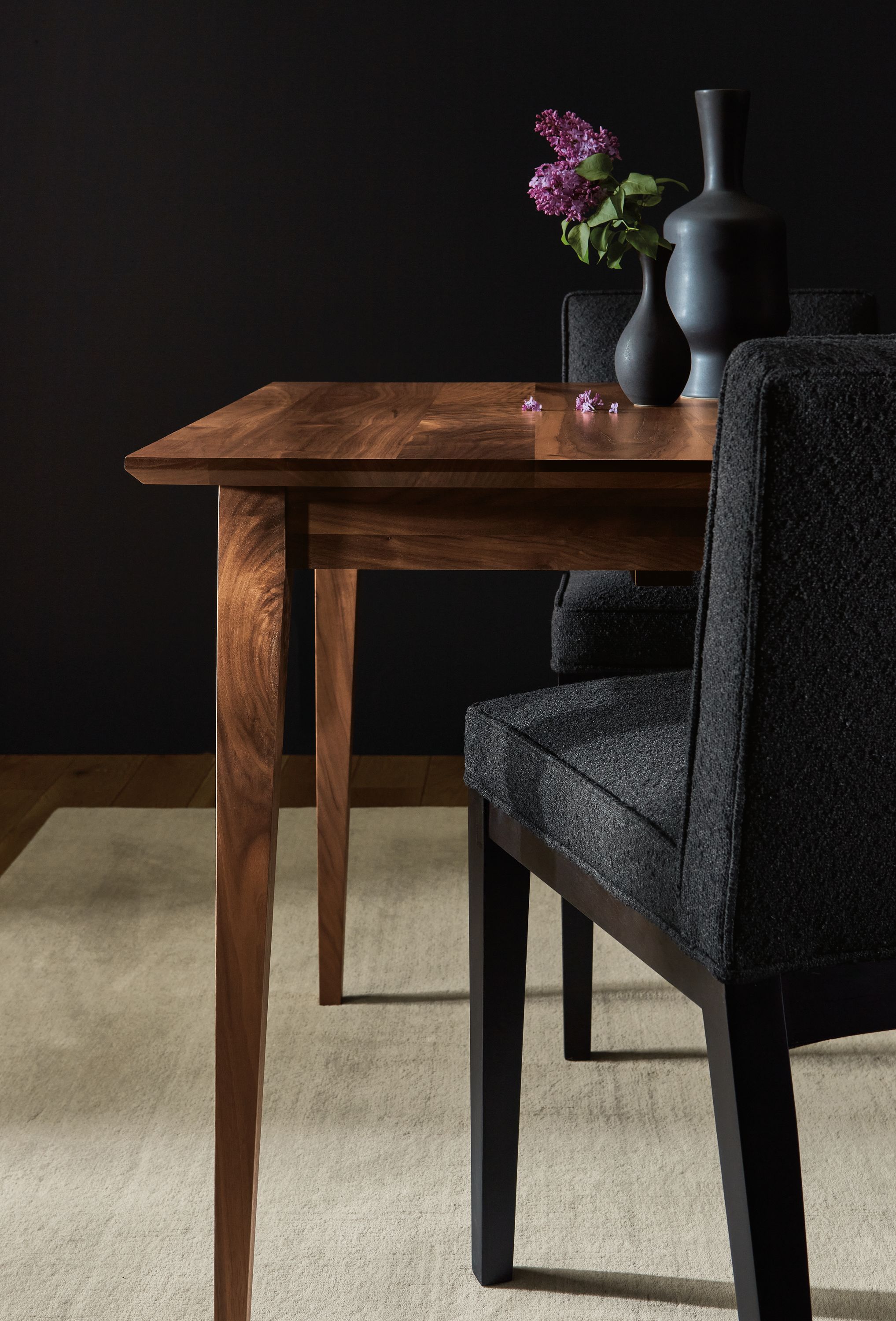 Detail of Adams 60-wide extension table in walnut and 2 Ansel side chairs in Declan Ebony fabric.