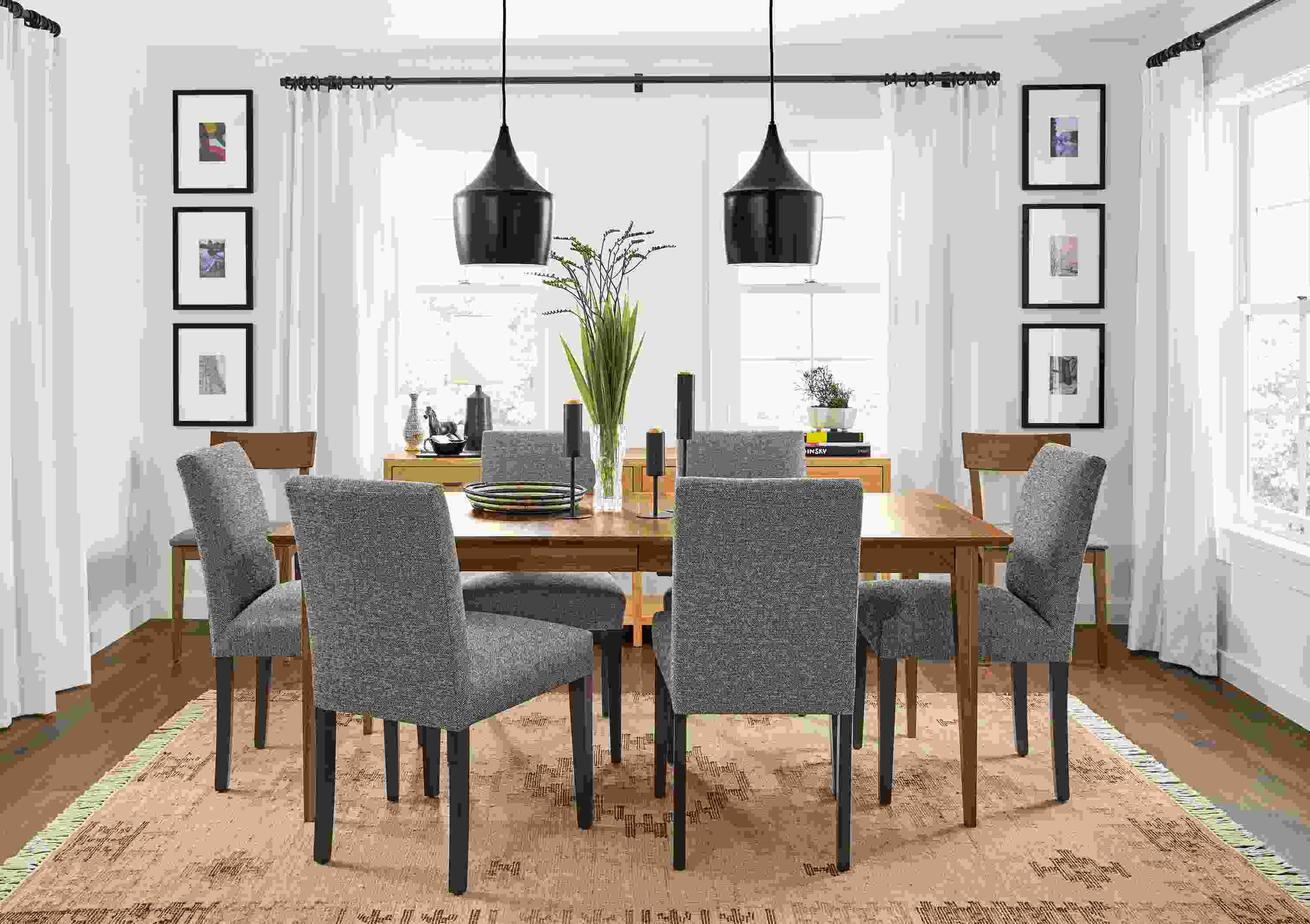 Detail of Adams extension table in walnut and Peyton chairs in Tatum Salt fabric in a dining room.