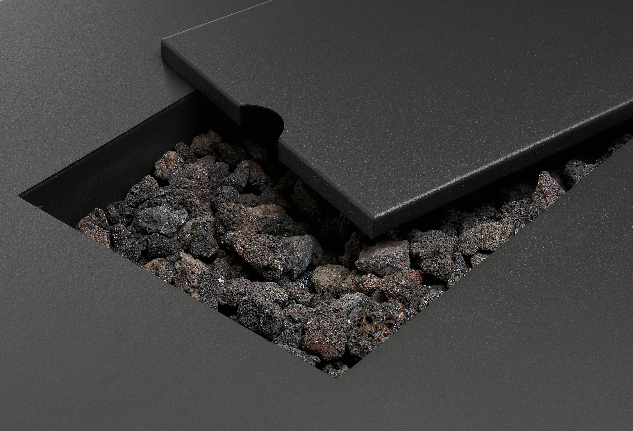 detail of cover and stone on top of adara outdoor fire table in graphite.