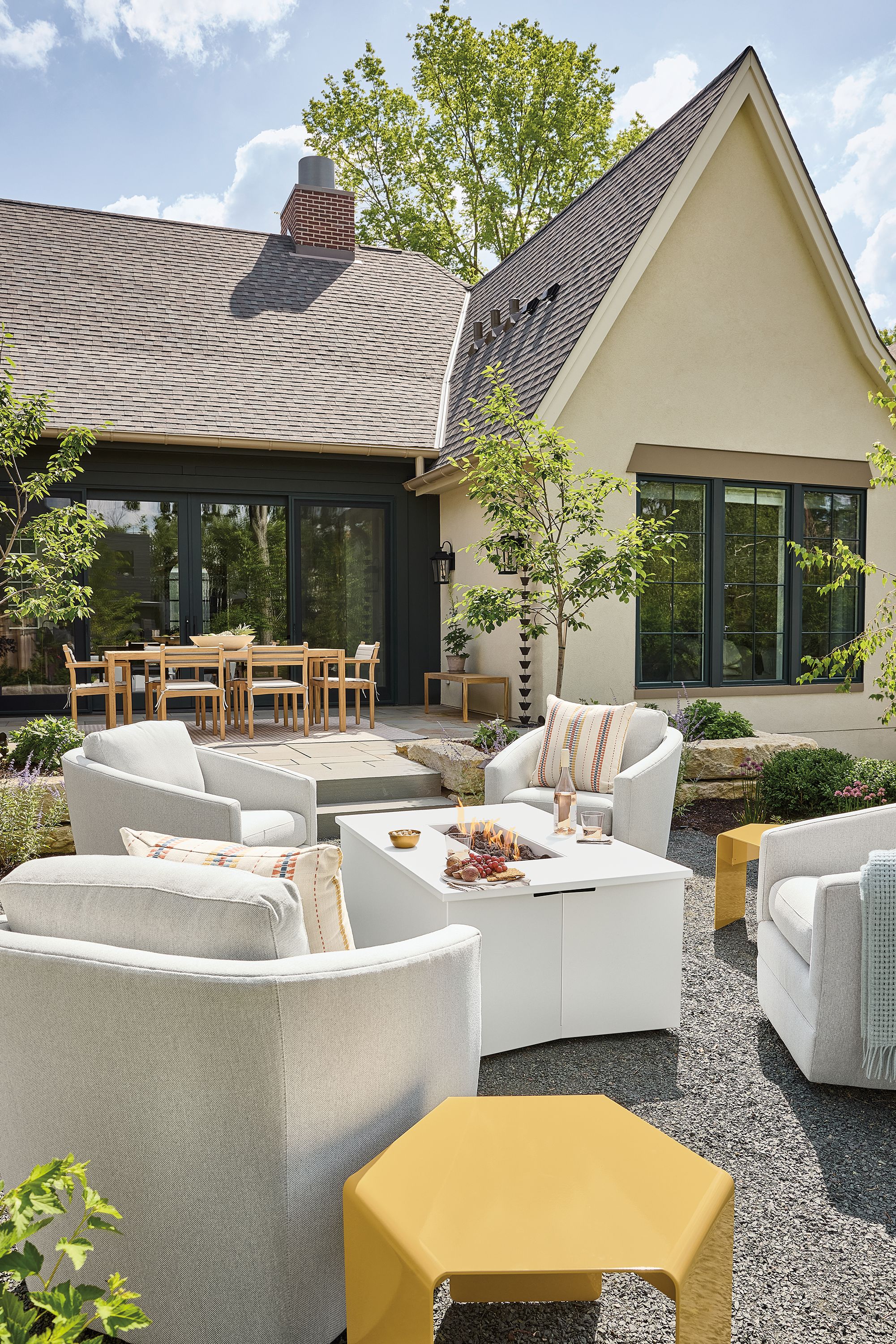 Outdoor seating area with lit adara propane fire table in white and 4 sunford swivel chairs in mist grey.