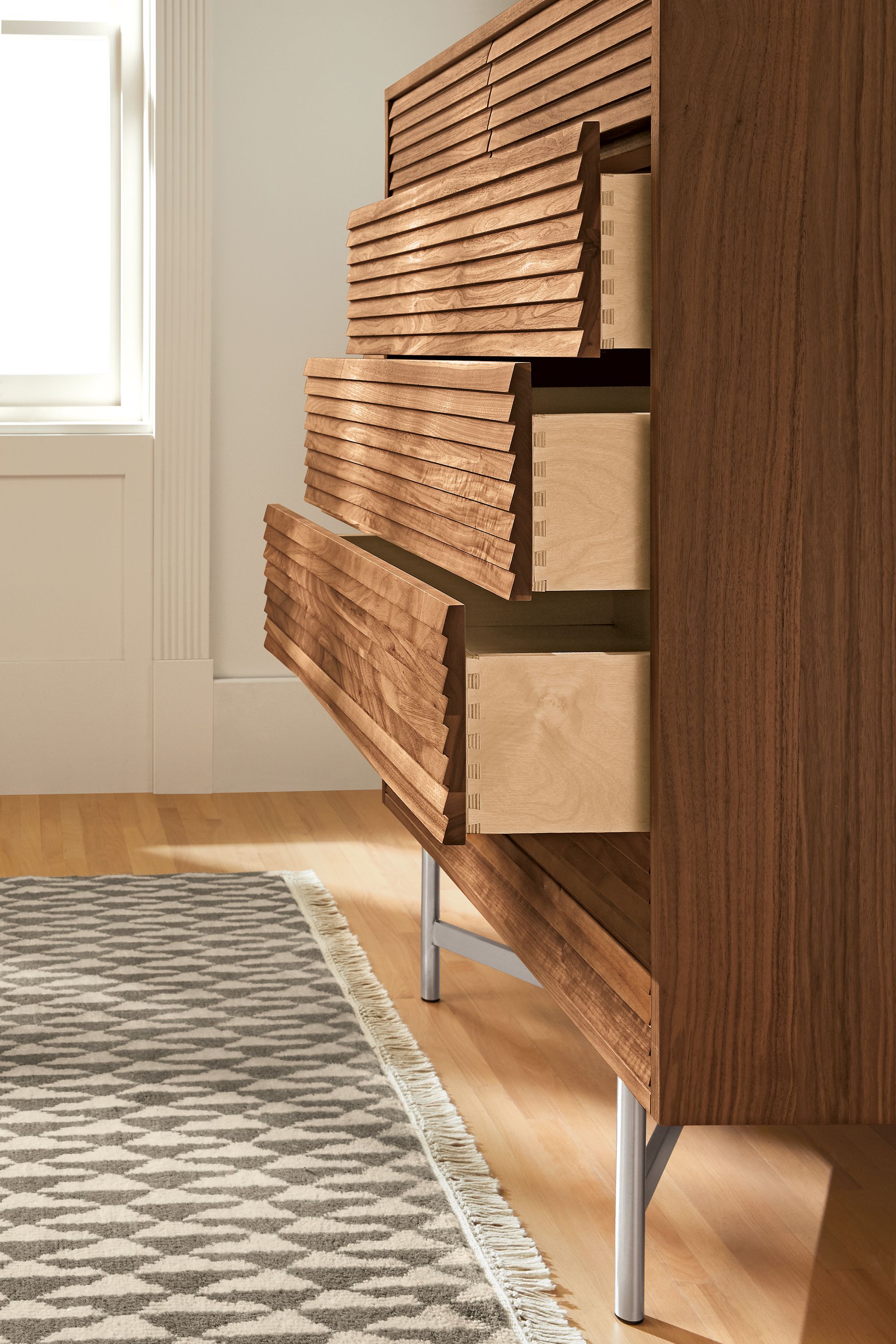 Side view of Adrian six-drawer dresser shown with drawers open different amounts.