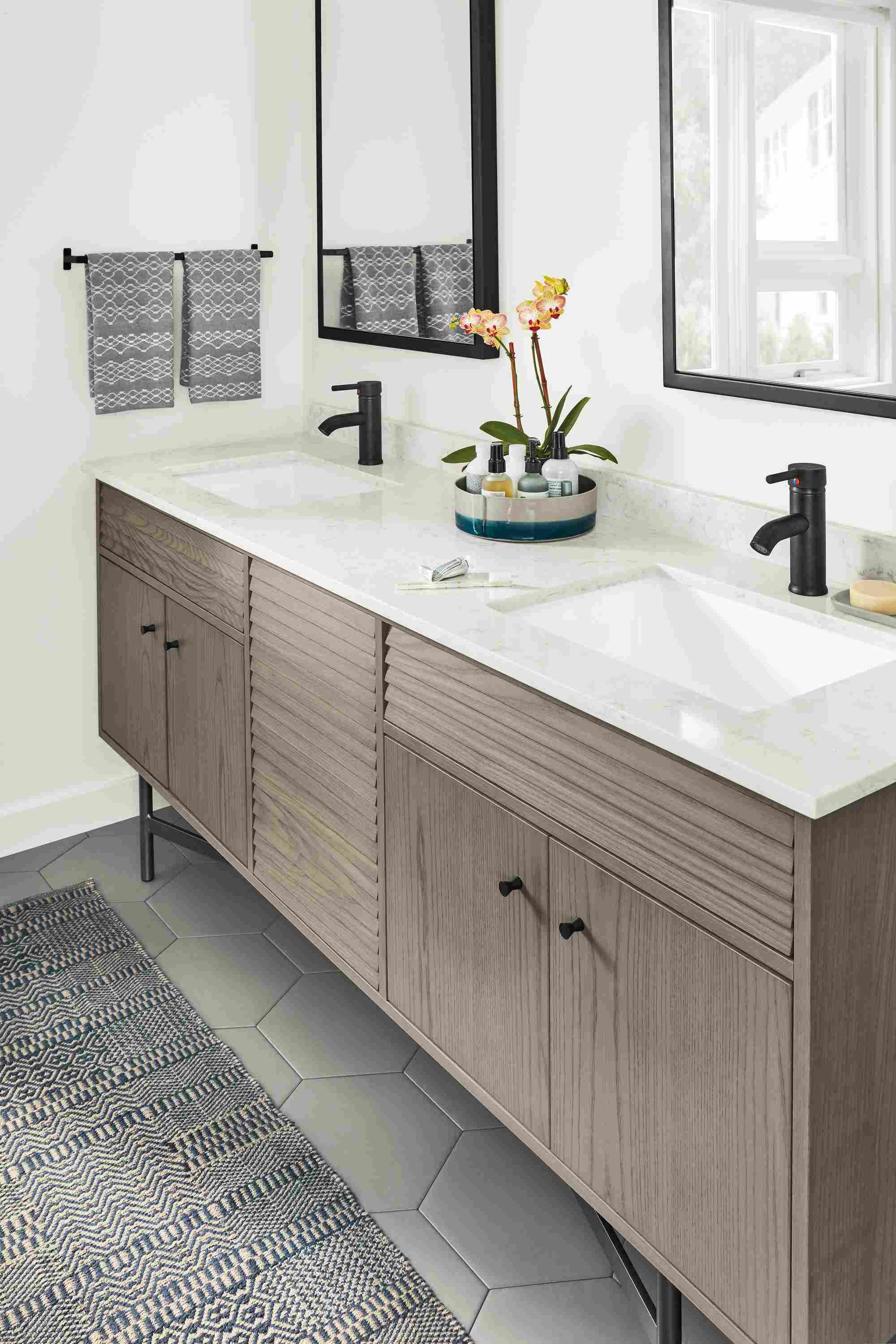 Bathroom with detail of Adrian bath vanity cabinet in shell on ash with marbled white quartz top.