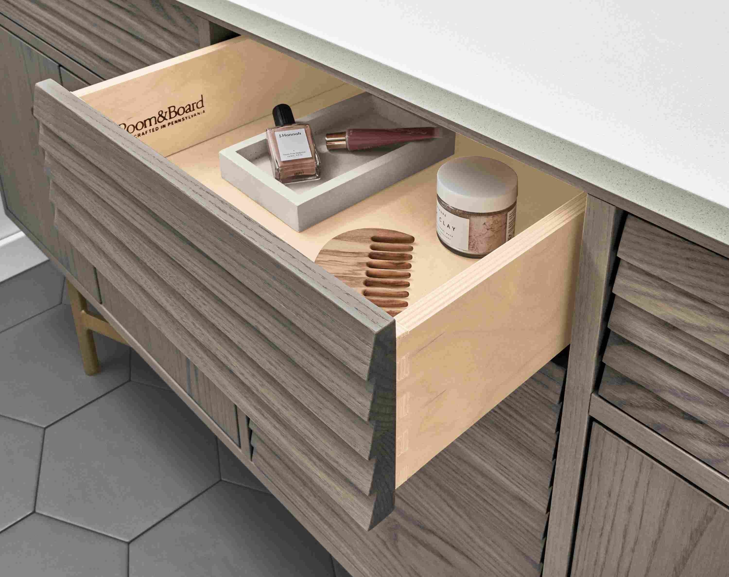 Detail of items inside drawer of an Adrian vanity in shell on ash with a white quartz top.