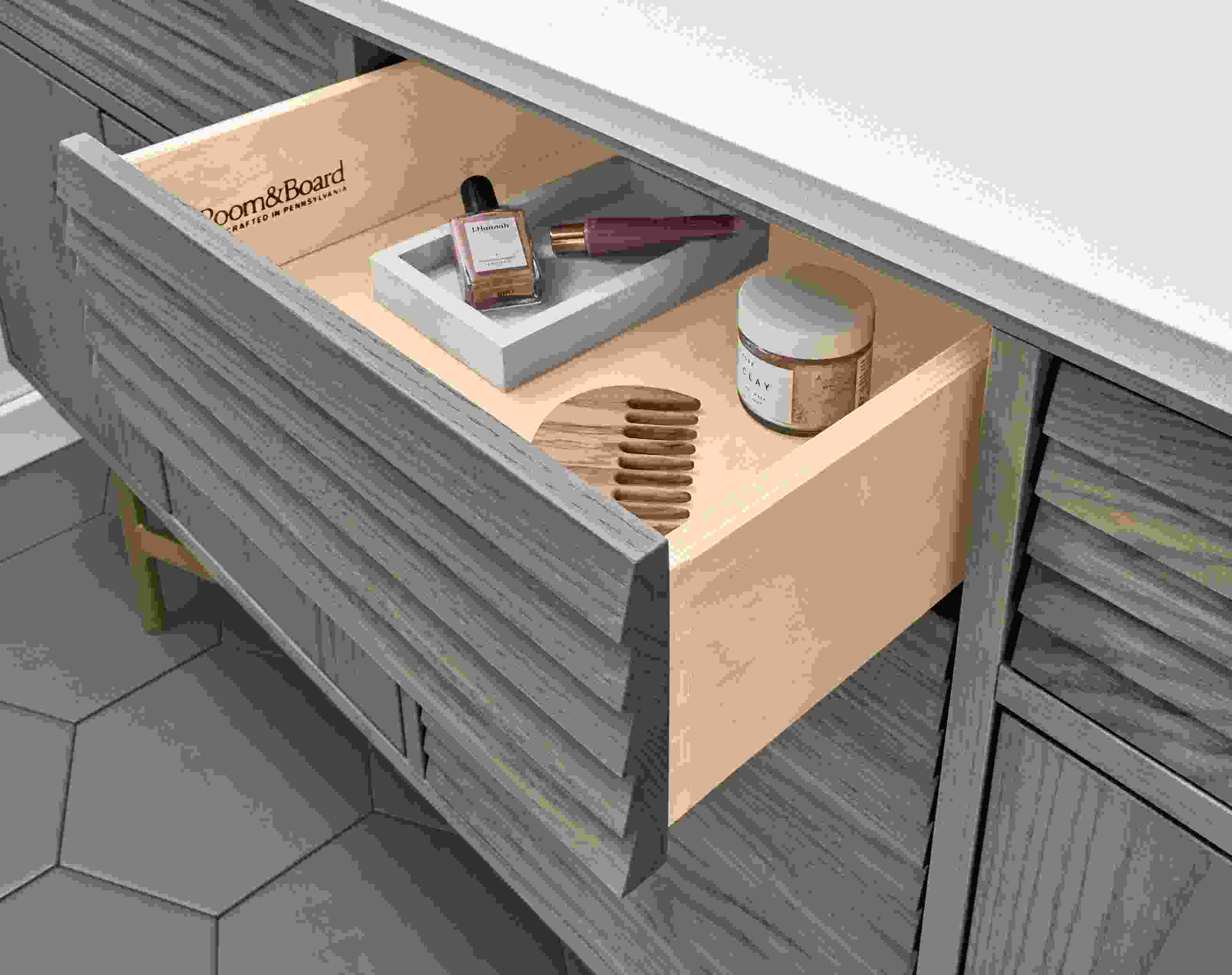 Detail of items inside drawer of an Adrian vanity in shell on ash with a white quartz top.