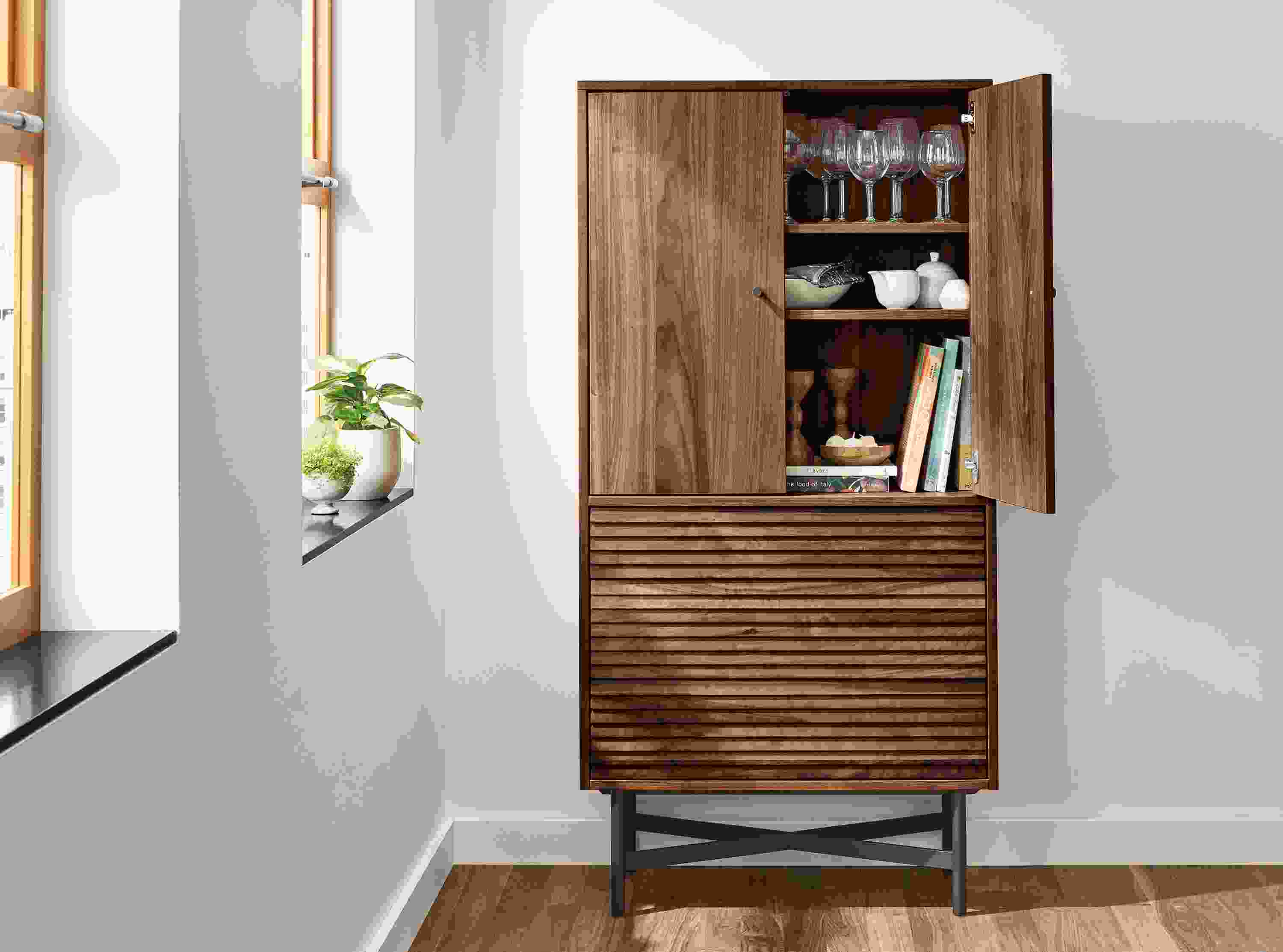 Detail of Adrian storage cabinet in walnut with right door open.
