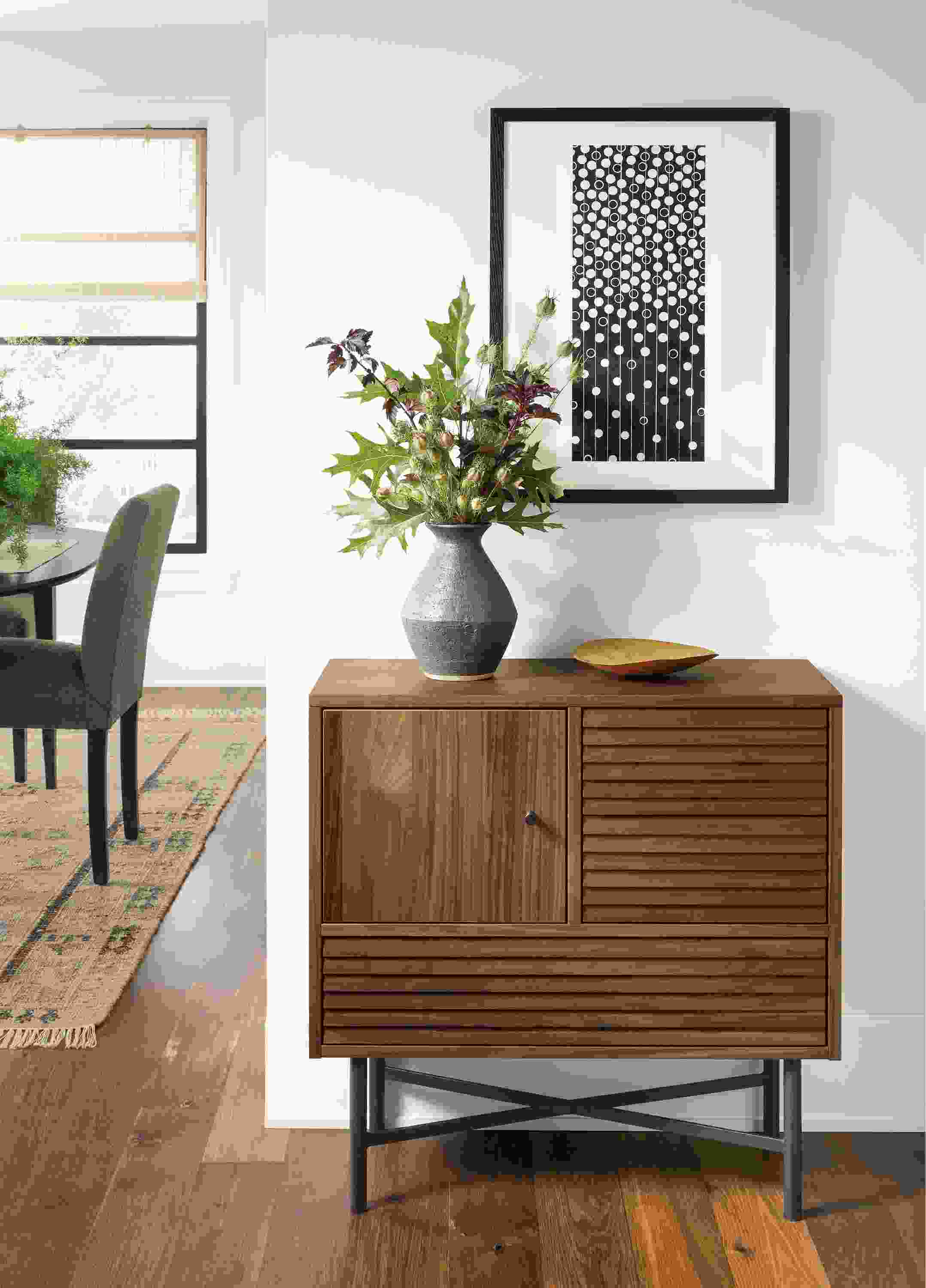 Detail of Adrian storage cabinet in walnut and natural steel in an entryway.