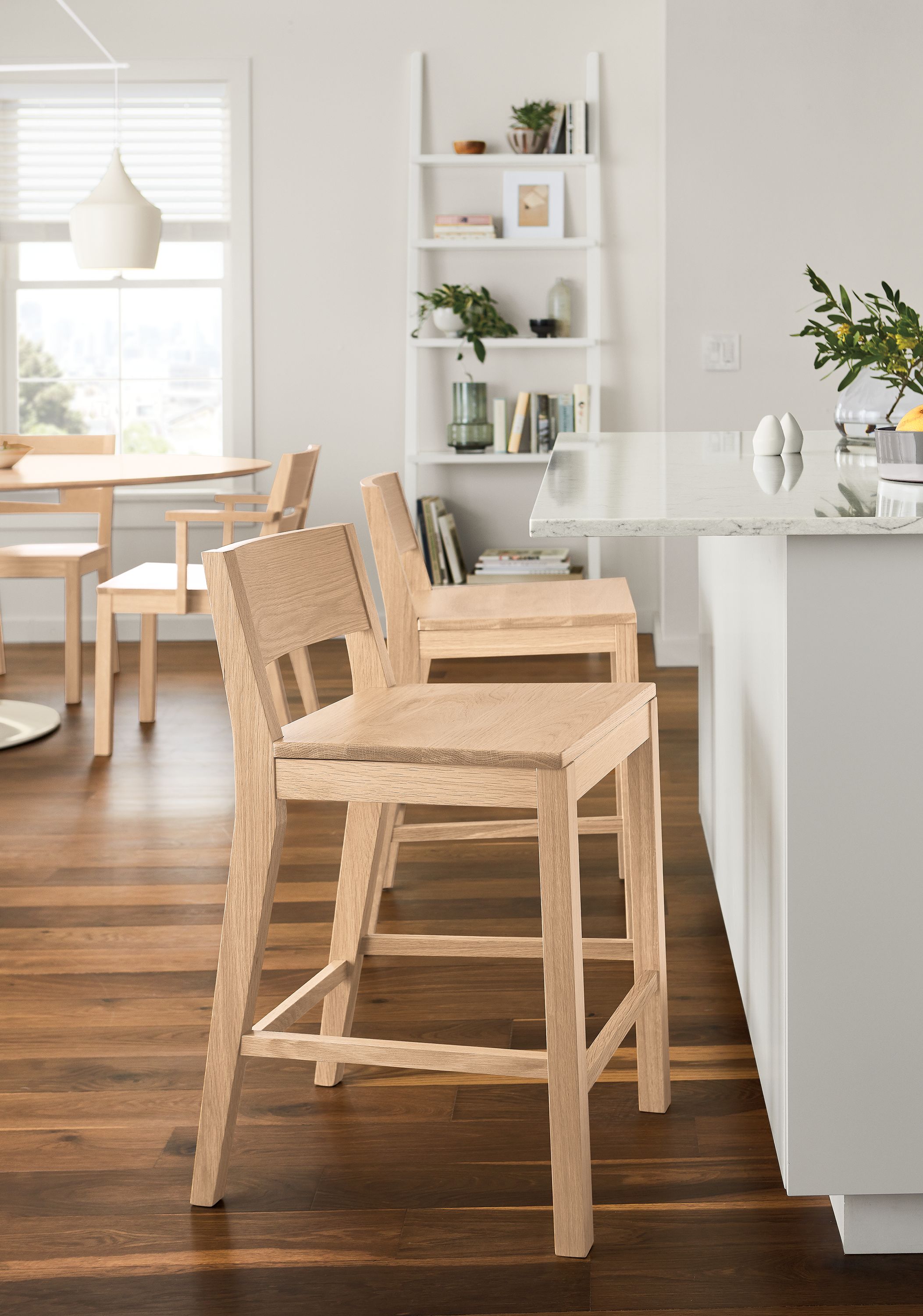 Kitchen counter with 2 afton counter stools with wood seat in salt on red oak and aria oval table in salt on red oak.