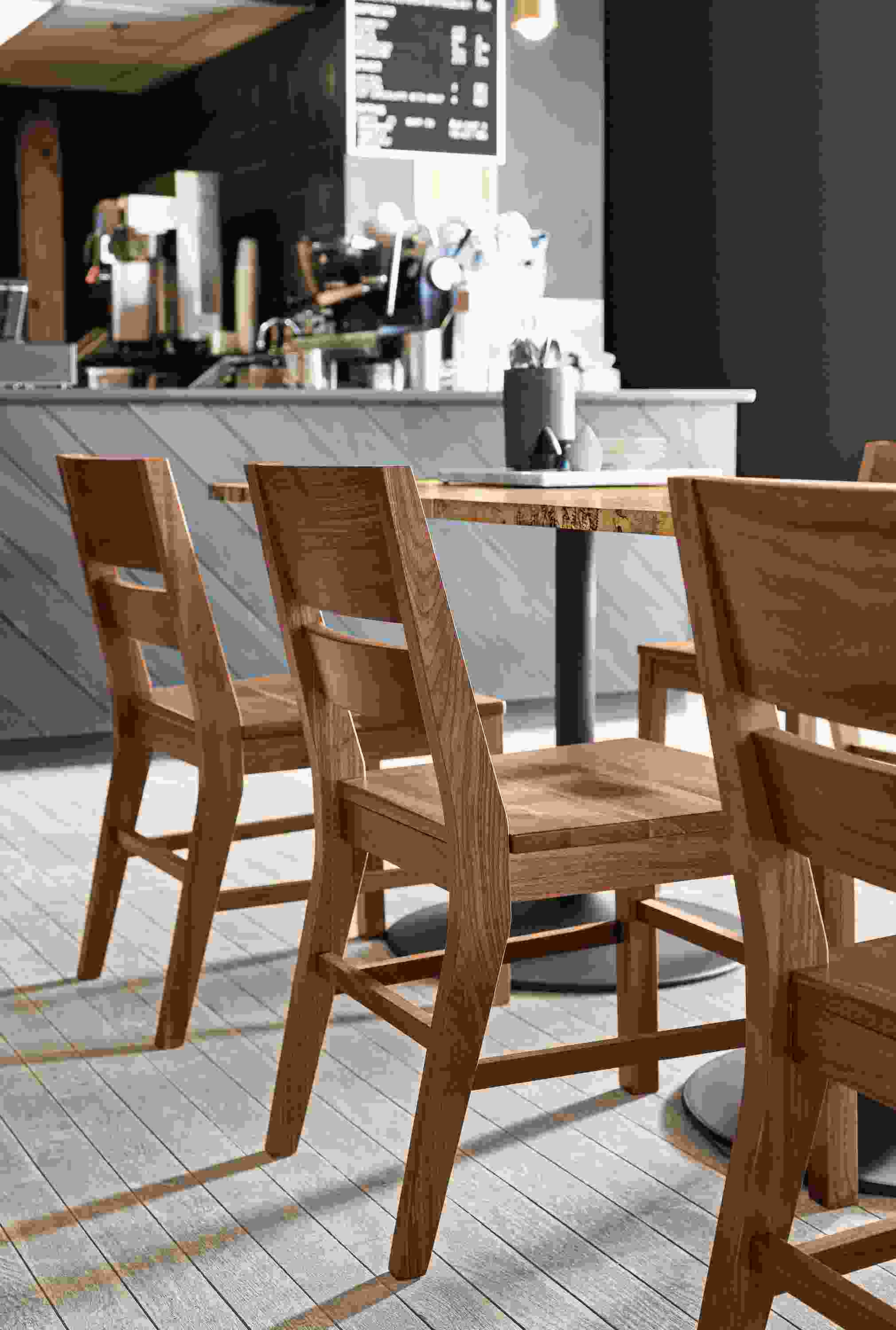Afton side chairs in walnut and Aria table in spalted sugarberry and graphite in a coffee shop.