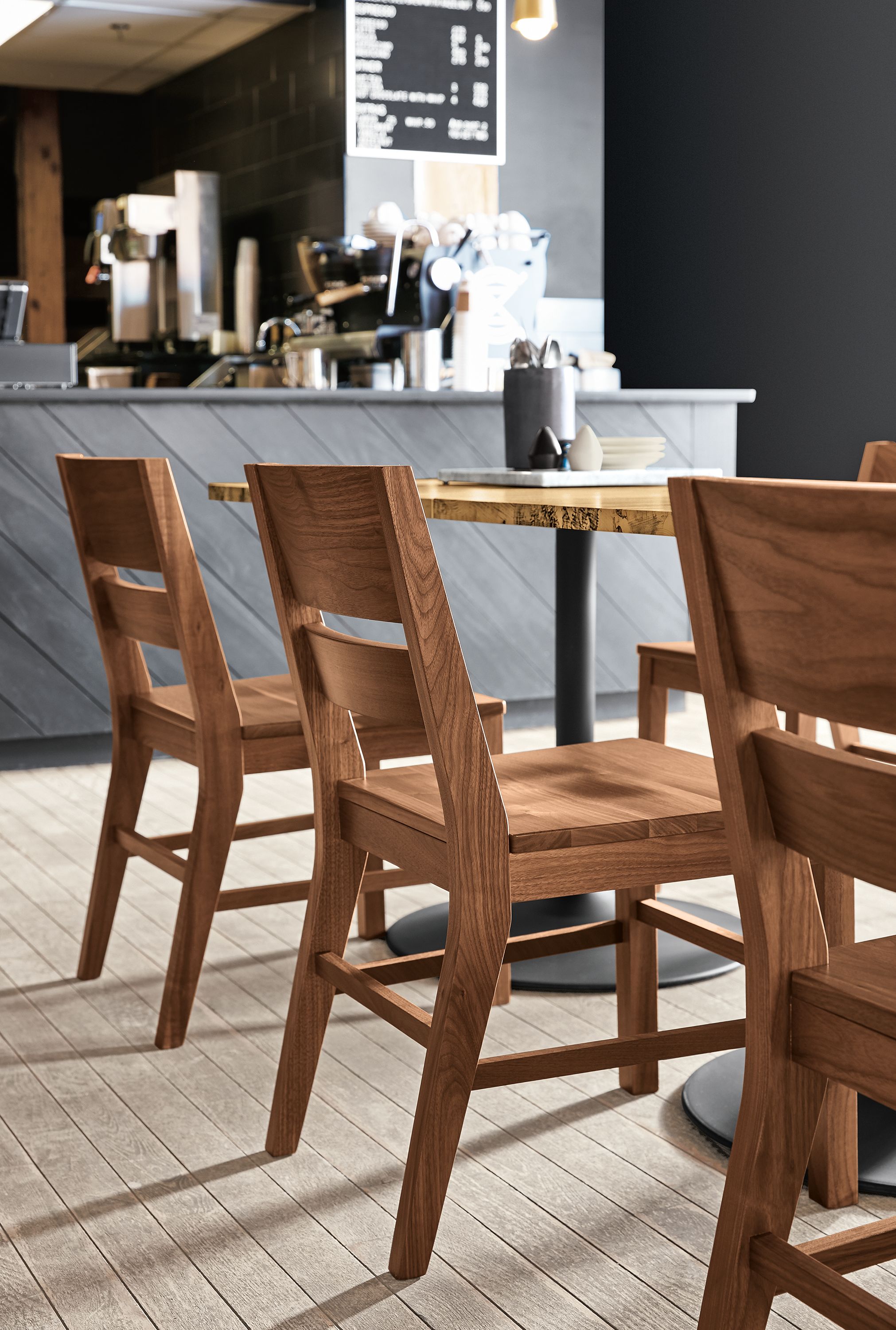 Afton side chairs in walnut and Aria table in spalted sugarberry and graphite in a coffee shop.