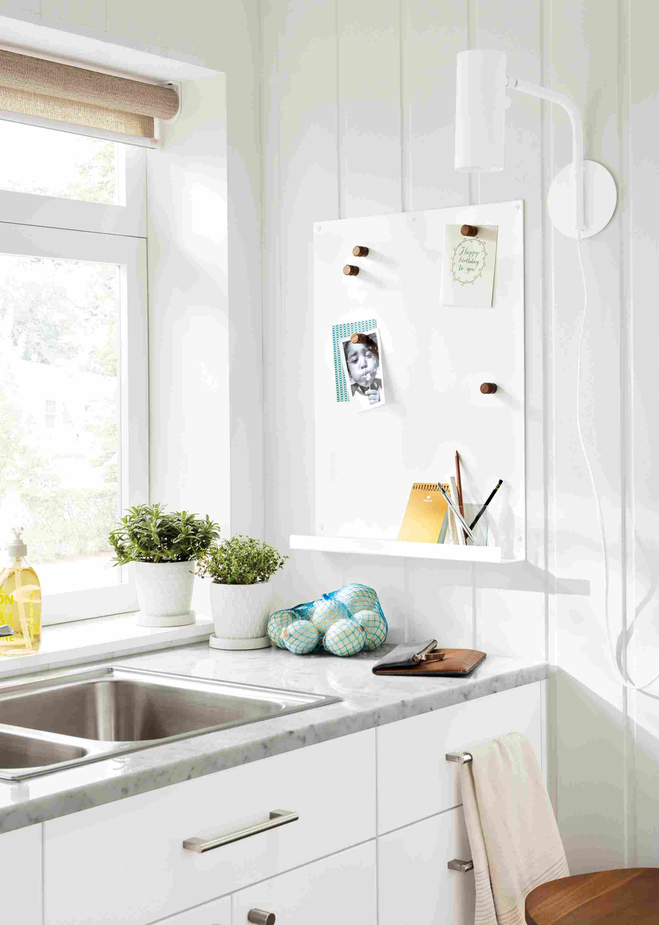 Detail of Agenda magnetic board in white over kitchen sink counter.