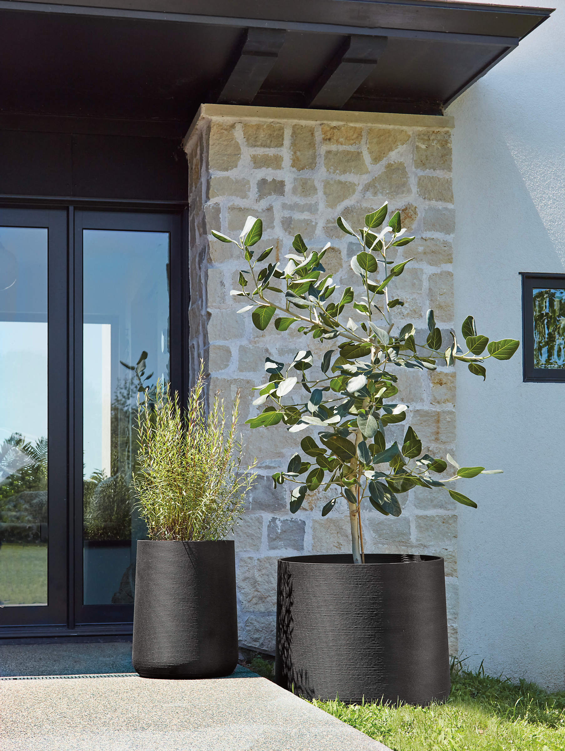 One 18-round and one 30-round Ajax planters in black on porch.