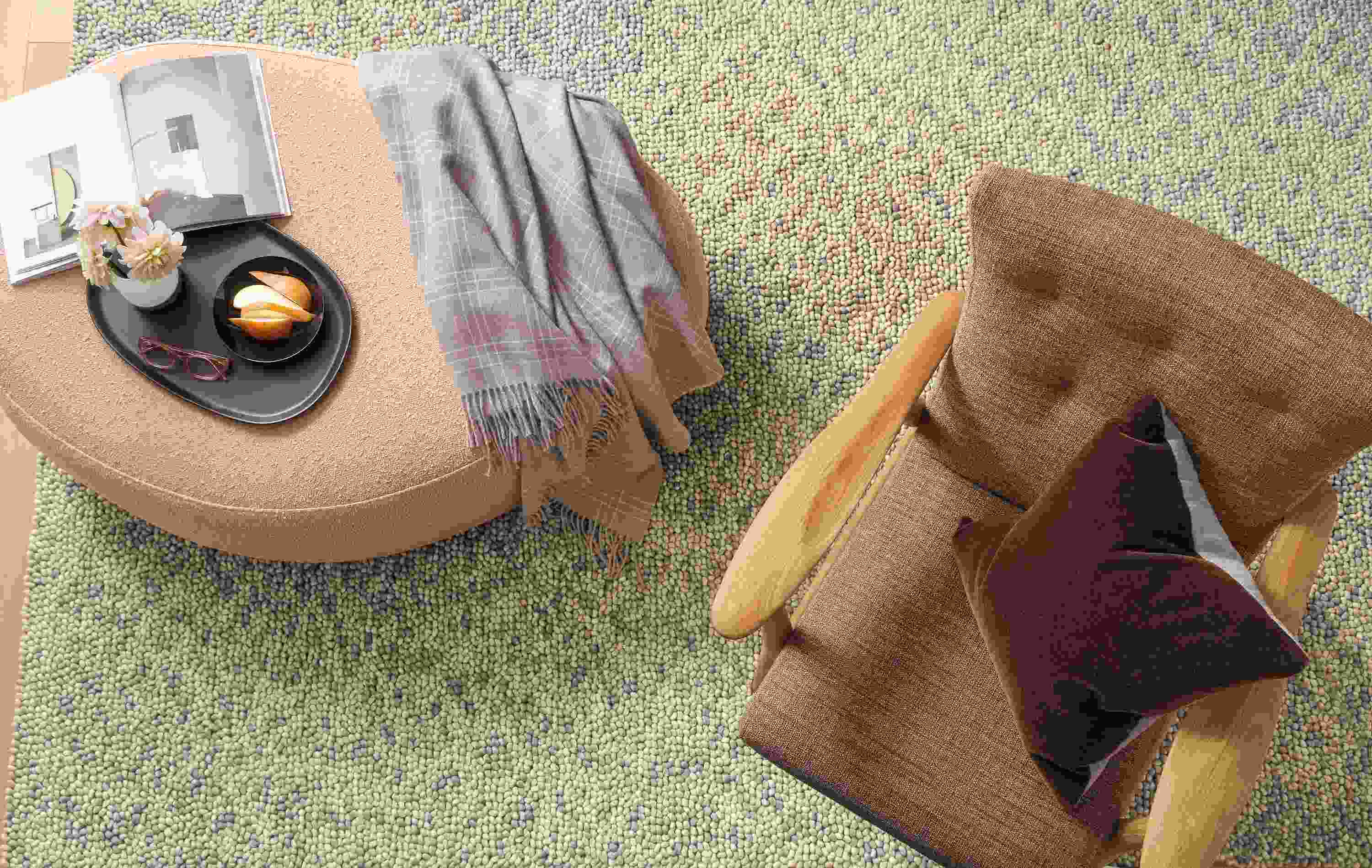 Overhead detail of Asher ottoman in Declan Blush fabric beside Jonas chair and Hastings rug in Ivory/Taupe.