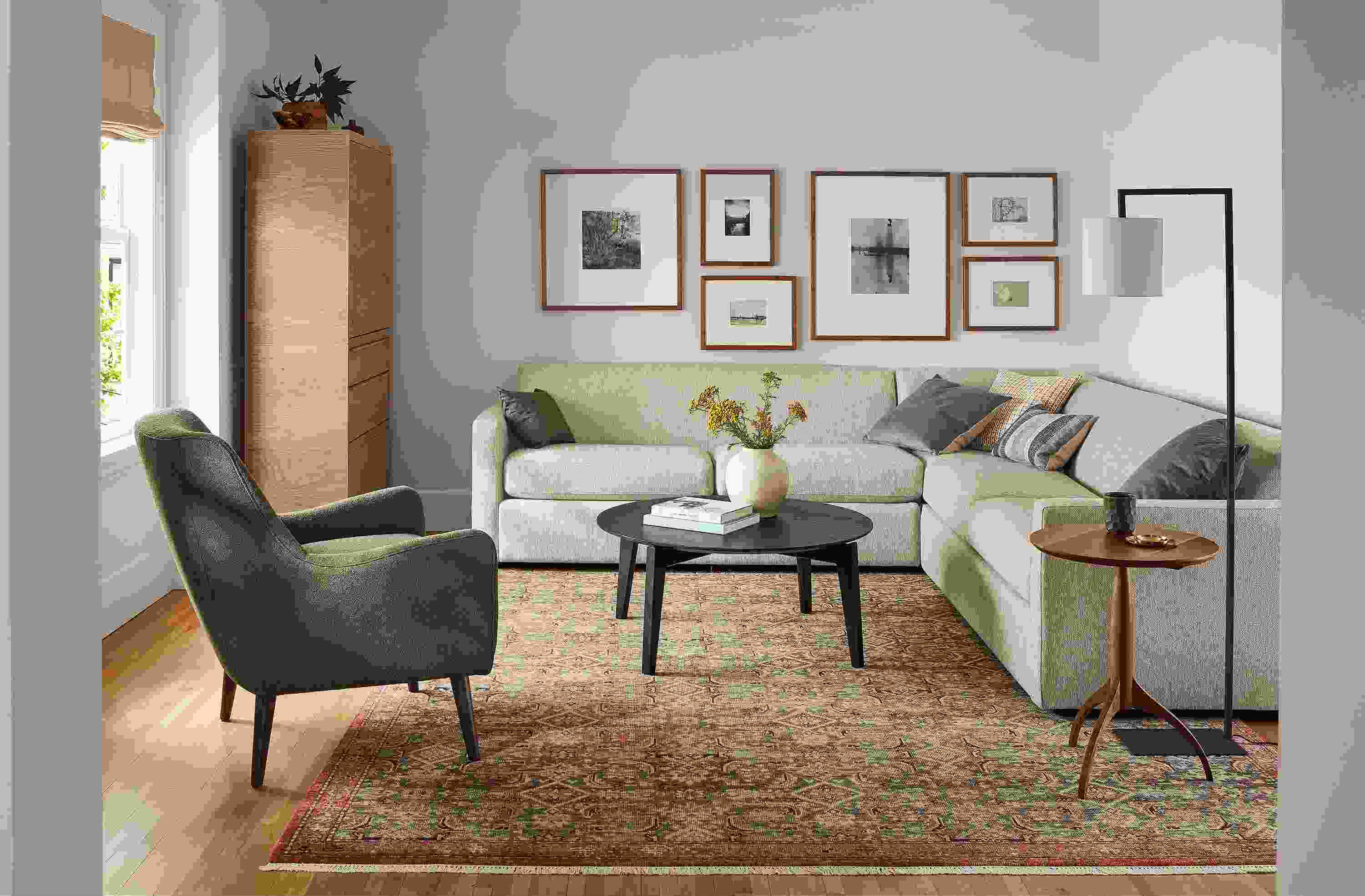 Living room with Alex sectional in tepic oatmeal, Orlin round coffee table in charcoal and Quinn chair in declan olive.
