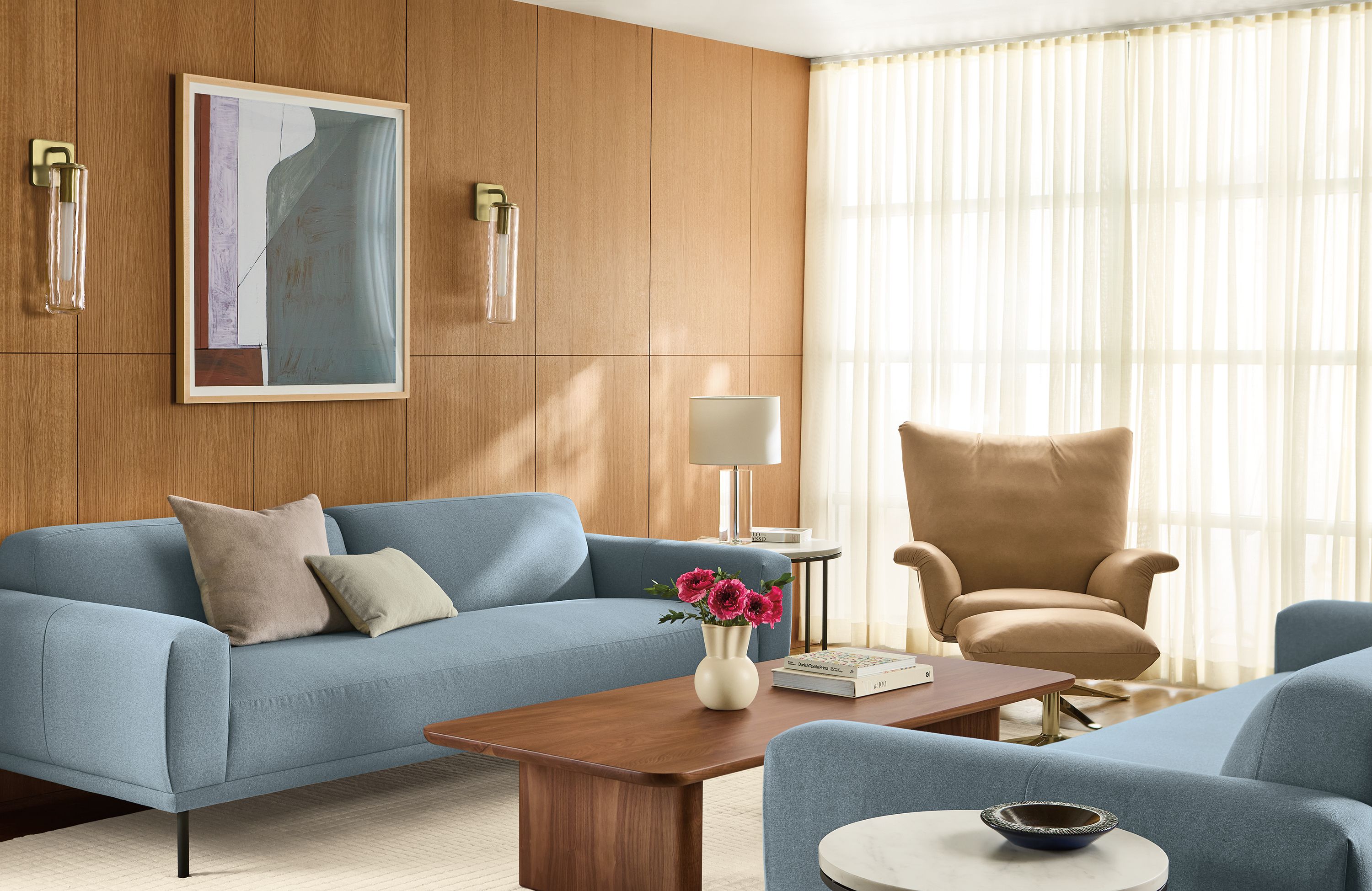Living room with Ali 94-wide bench cushion sofa in Myers Slate, Paris swivel chair and ottoman in Fiero Camel leather and Safira rug in ivory.
