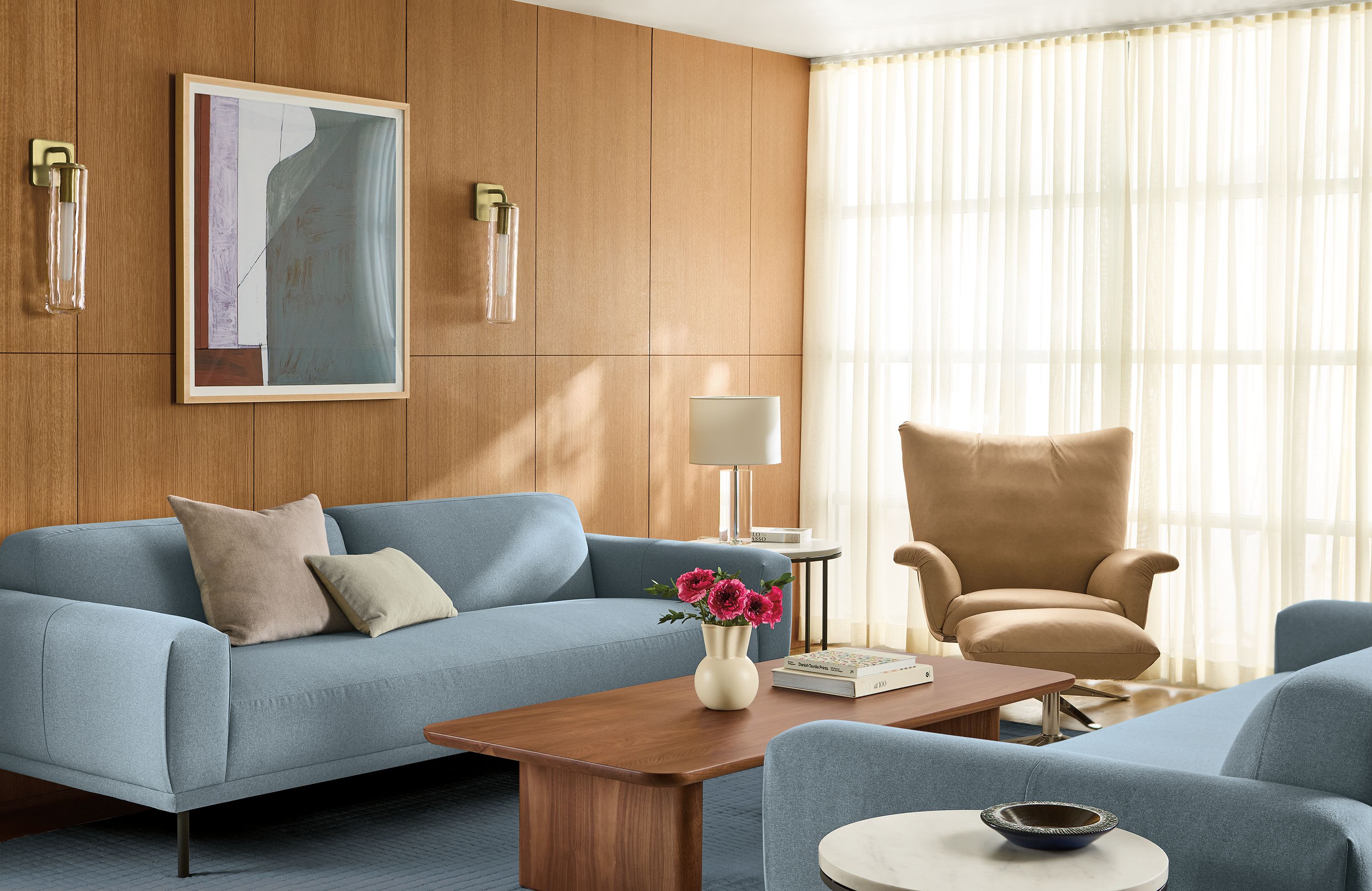 Living room with Ali 94-wide bench cushion sofa in Myers Slate, Paris swivel chair and ottoman in Fiero Camel leather and Safira rug in cadet