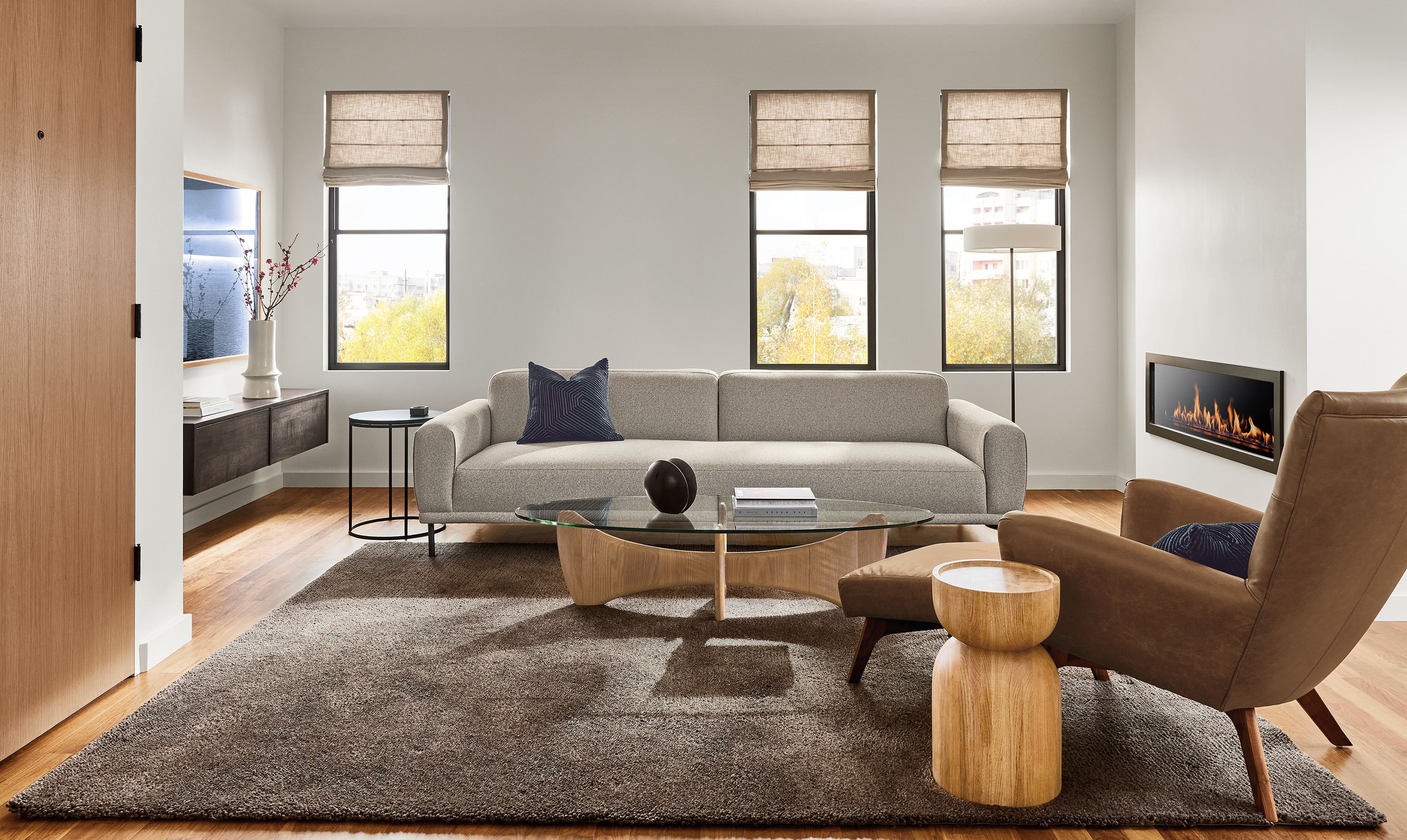 Living room with Ali 104-wide bench cushion sofa in tatum bone and Boden chair and ottoman in Palermo Bourbon leather.