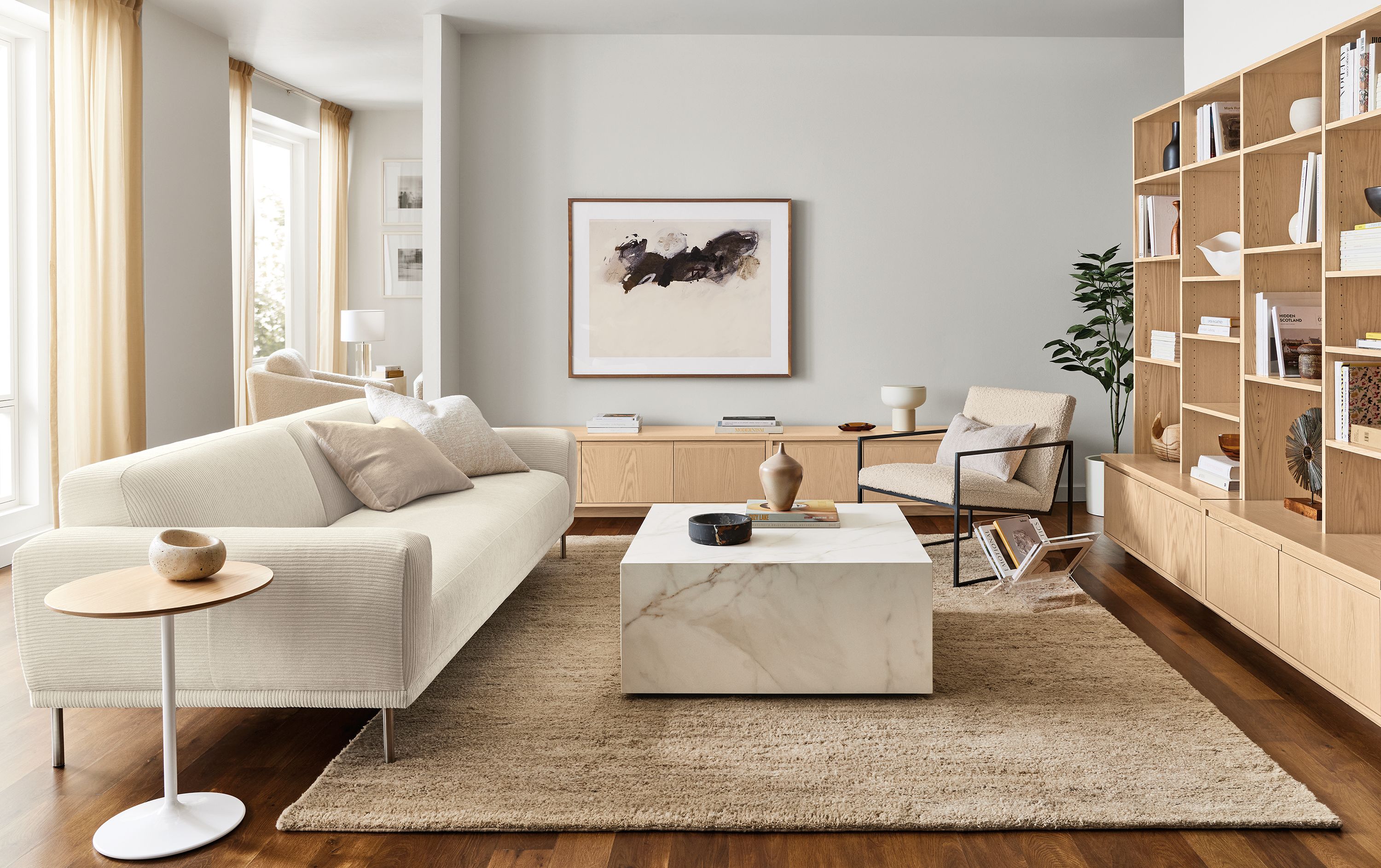 Living room with 94-wide bench cushion sofa in Brava Ivory, Novato chair in Dornick Ivory and Leona coffee table.