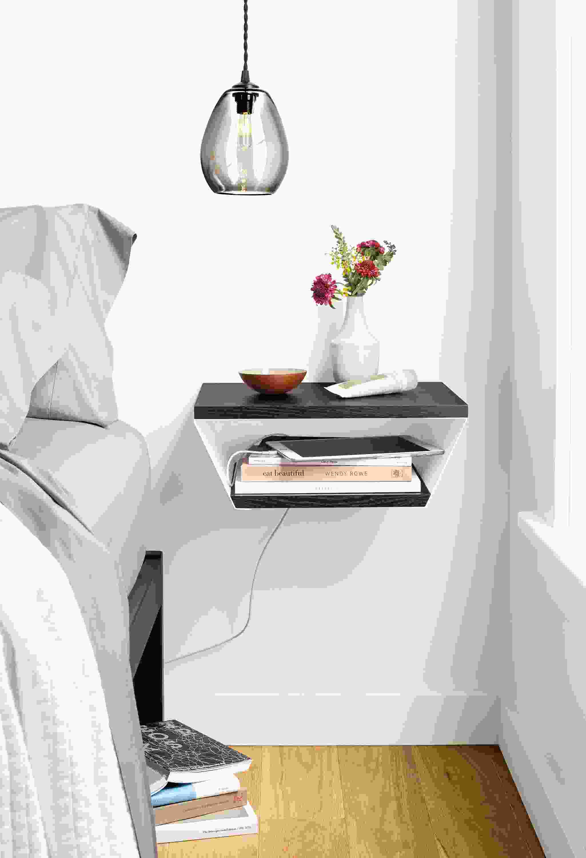Detail view of Alta wall shelf in white and charcoal near bed.