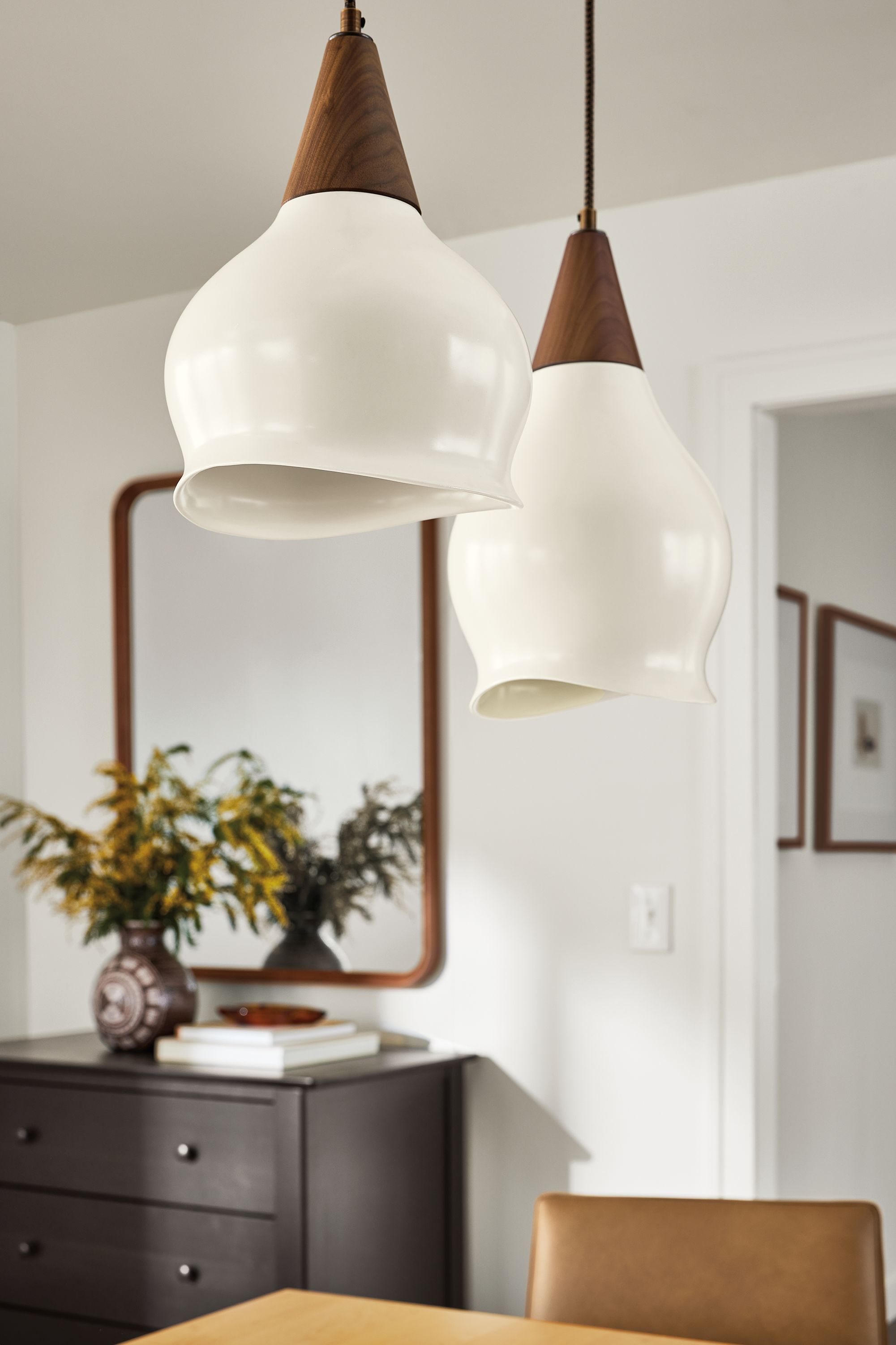 Detail of 2 Althea Pendants in 8 and 9-inch diameter in walnut and white in a dining room.