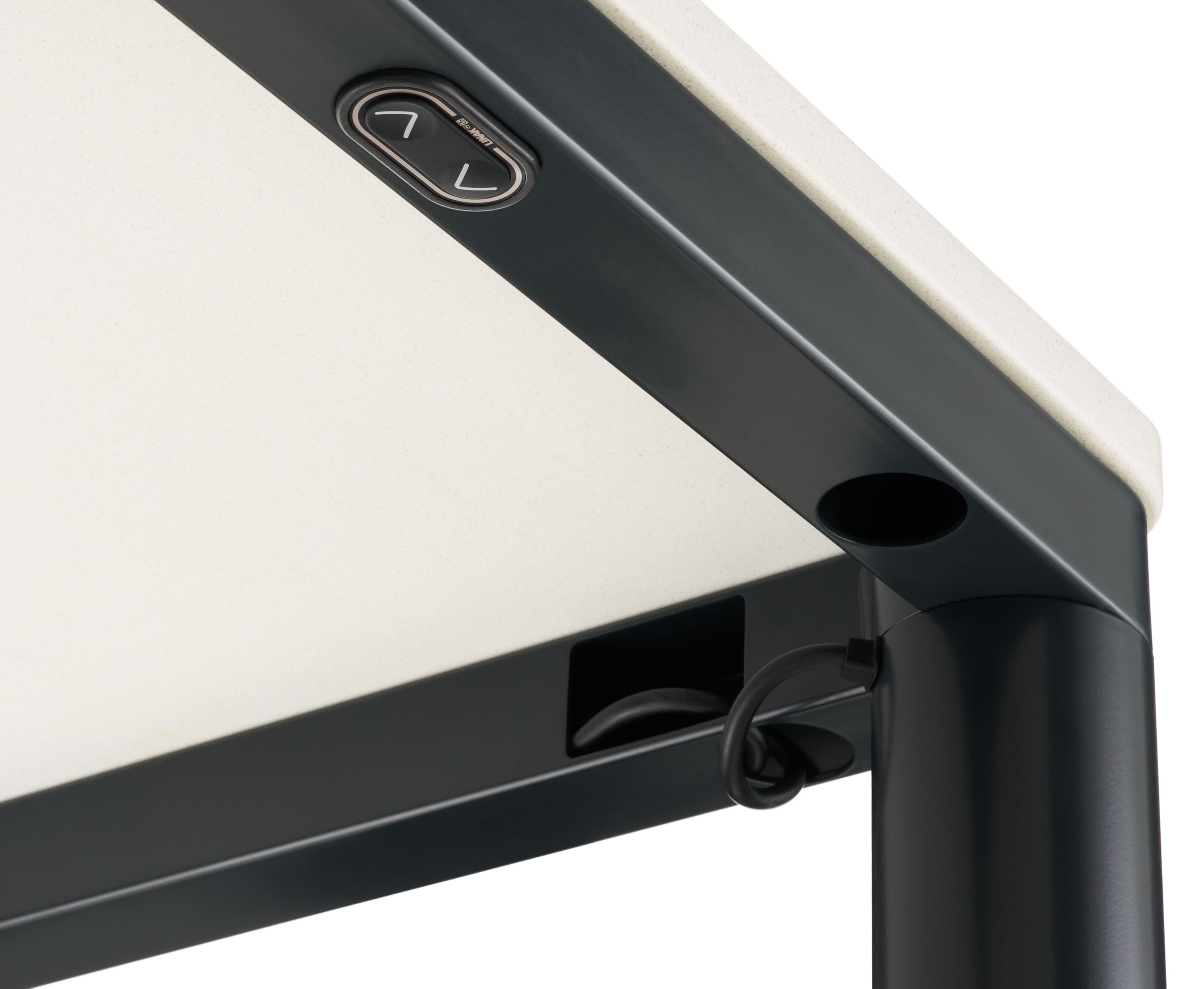 Detail of cord routing and height adjustment switch on an Ames adjustable standing desk in graphite and white quartz.