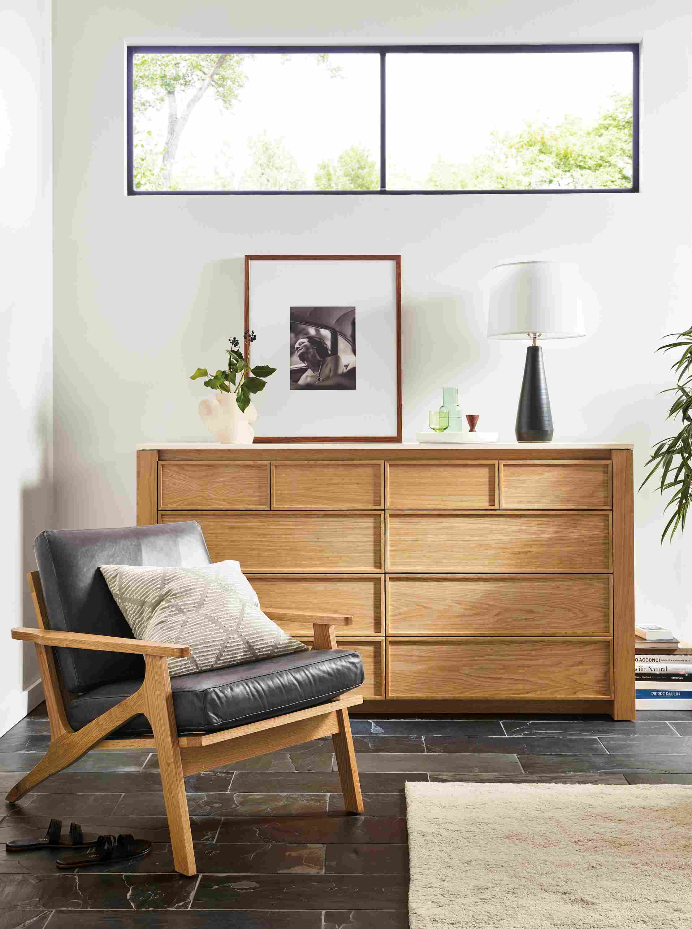 Living room with Amherst 72-wide 10-drawer dresser in white oak next to sanna chair in Vento Smoke leather.