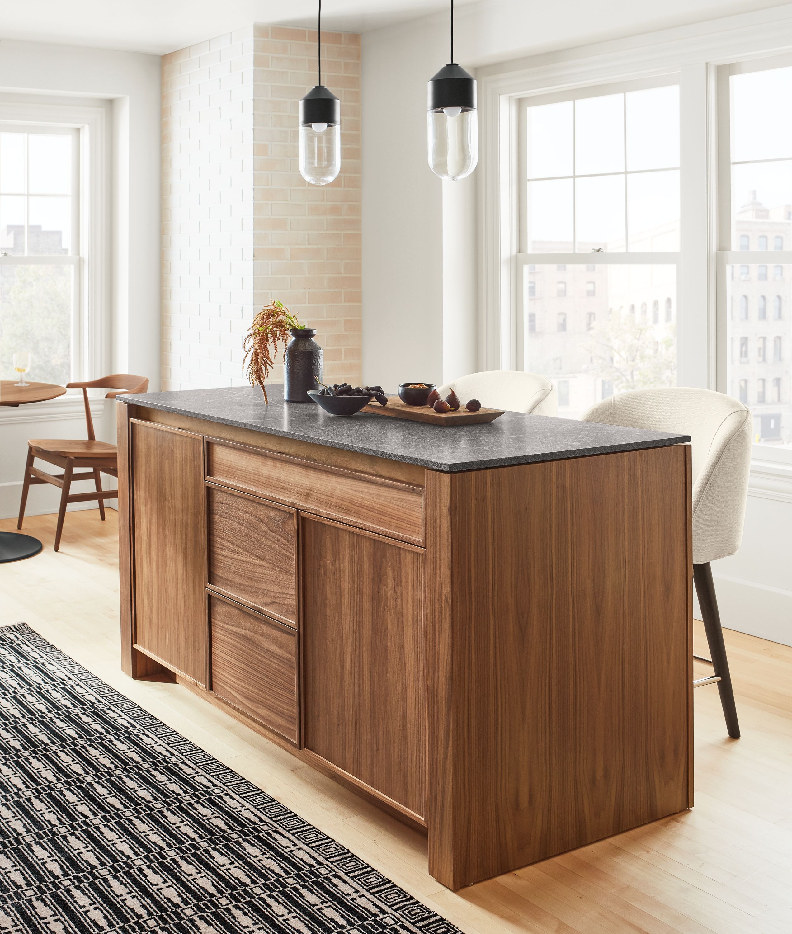 Amherst 60-wide Kitchen Island in walnut with Cora Swivel Counter Stool in Sumner Ivory and Ballad Pendants.