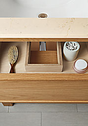 detail of amherst vanity drawer open to show u-shaped interior with bathroom accessories.
