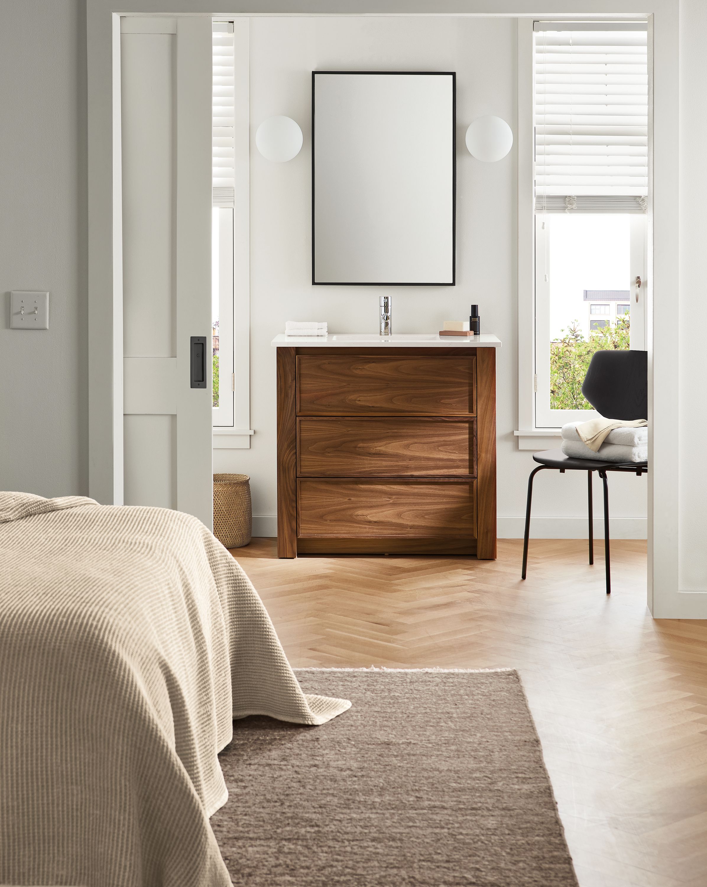 bedroom with 36-wide amherst vanity, hudson mirror, pike side chair, orbit sconces.