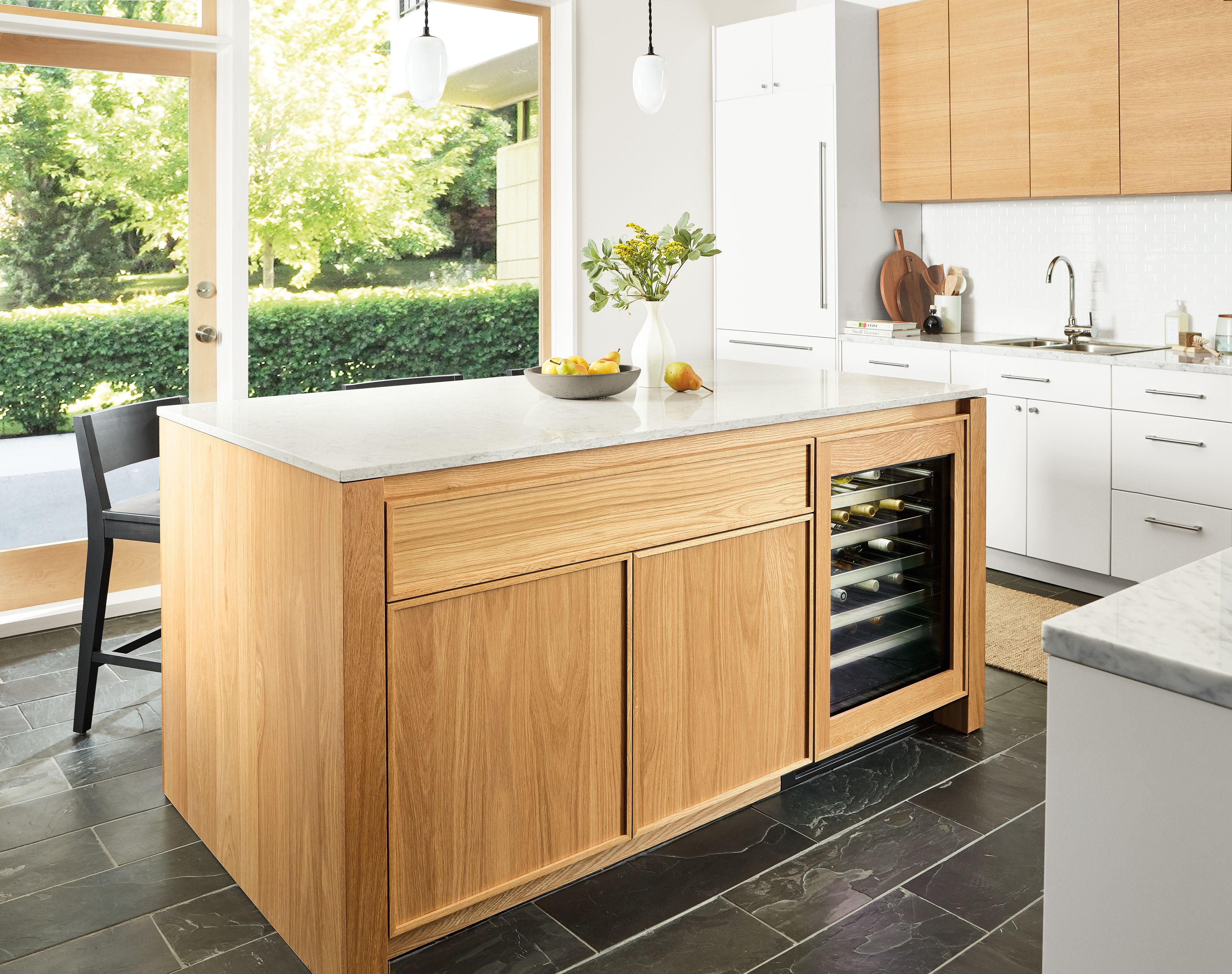 Kitchen with Amherst 72 wide kitchen island with glass door fridge, polar pendant lights and Selby rug in taupe.