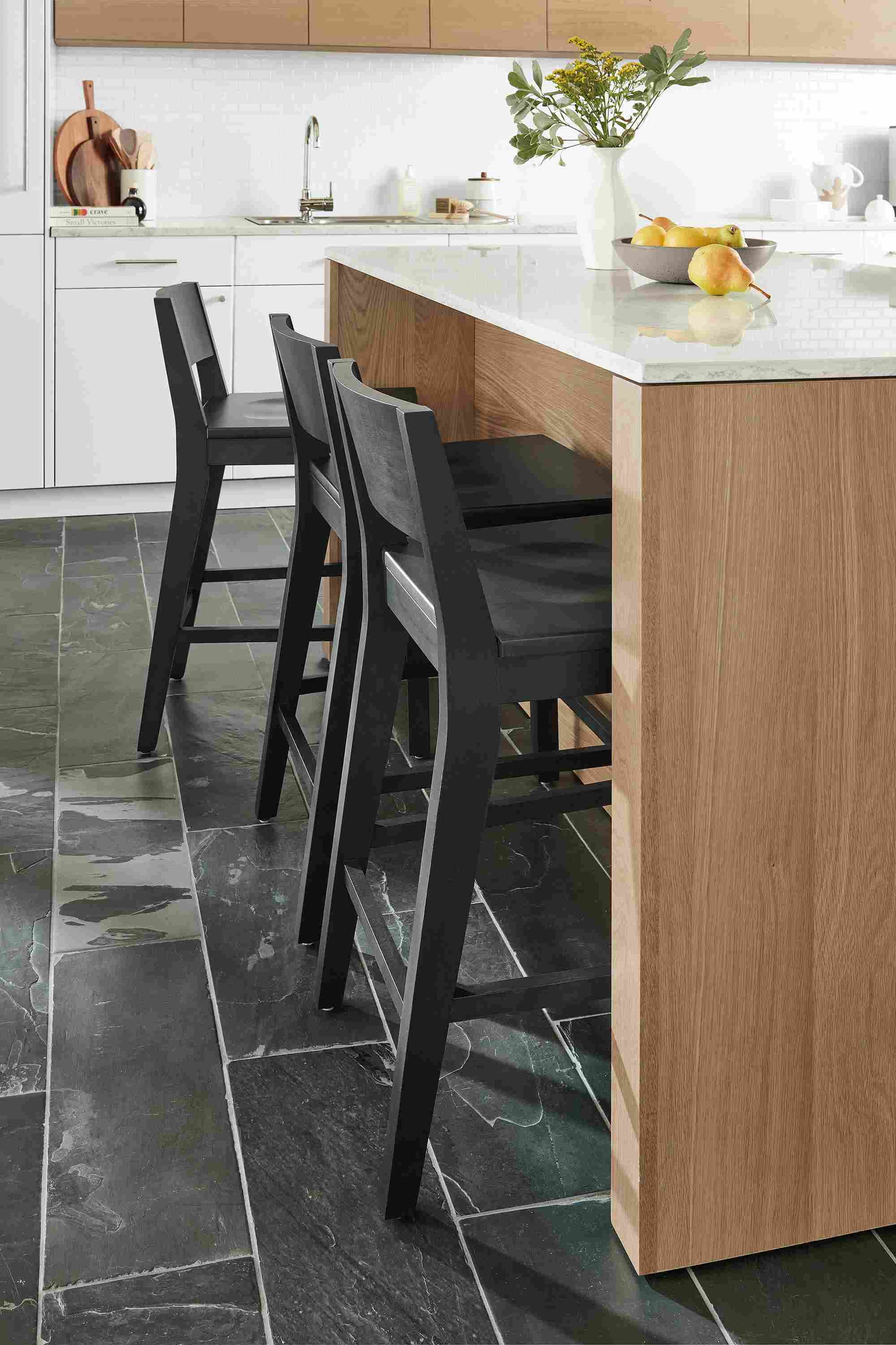 Kitchen with Amherst 72-wide kitchen island in rye on red oak with glass door fridge and Afton counter stools in charcoal.