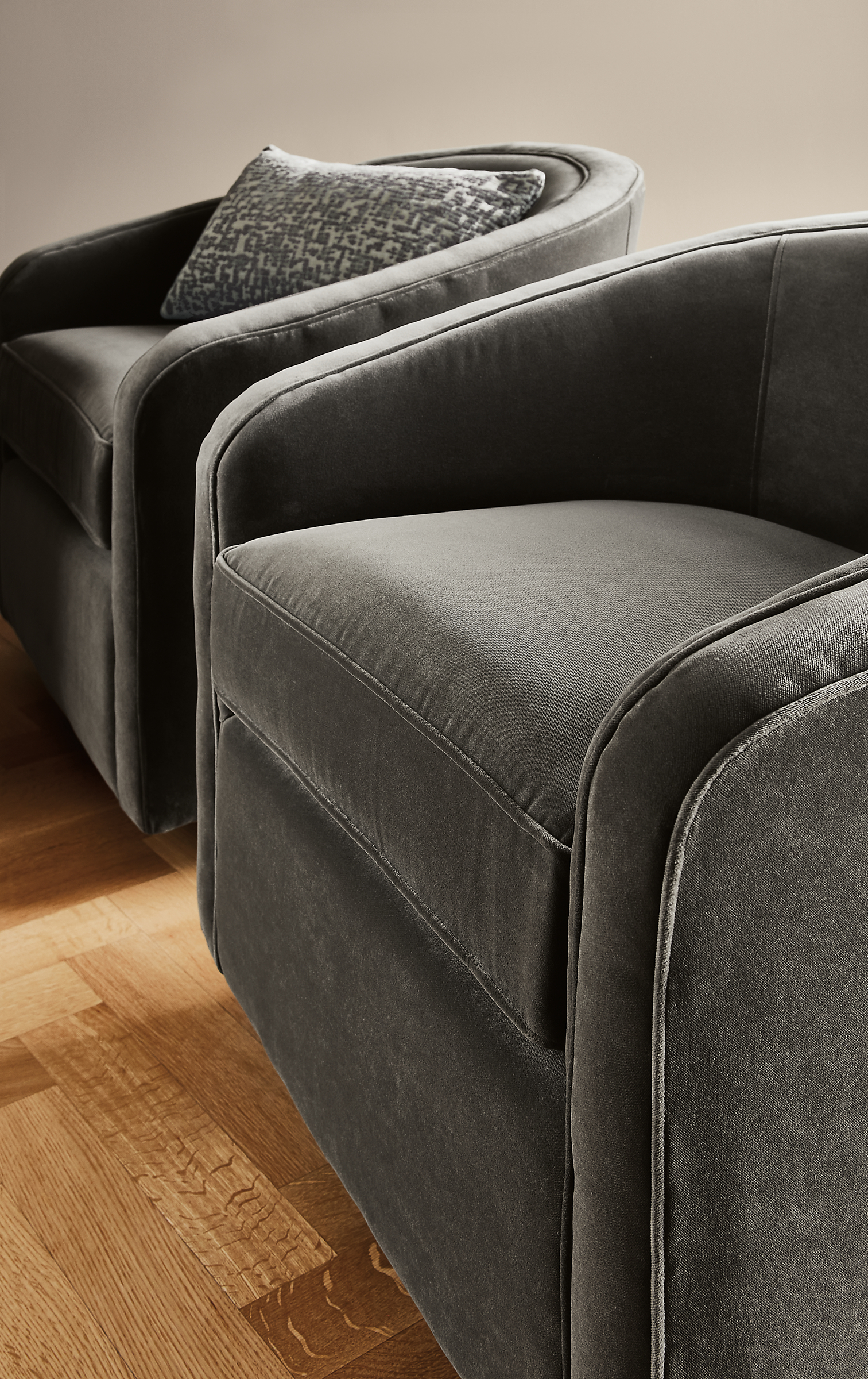 close-up of two amos swivel chairs in banks charcoal fabric.