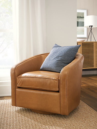 Detail of Amos swivel chair in Portofino Cognac leather in living room.