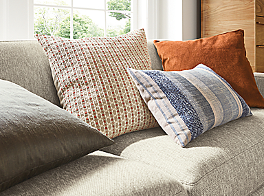 Detail of ansley pillow in brick, silk pillow in charcoal, tetra pillow in ink and wool velvet pillow in rust.