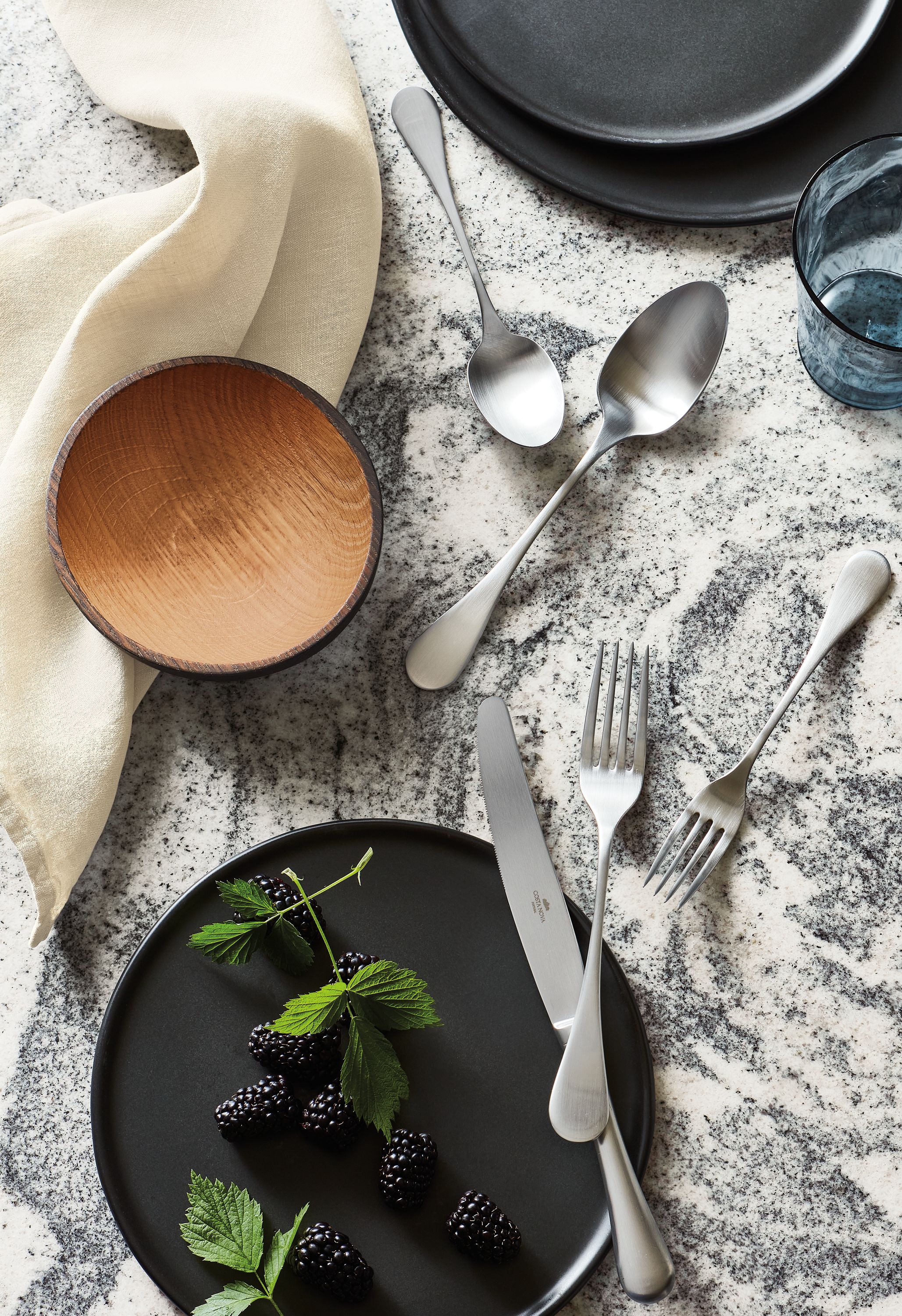 granite tabletop with antigo flatware, elliott bowl, nadia plates.