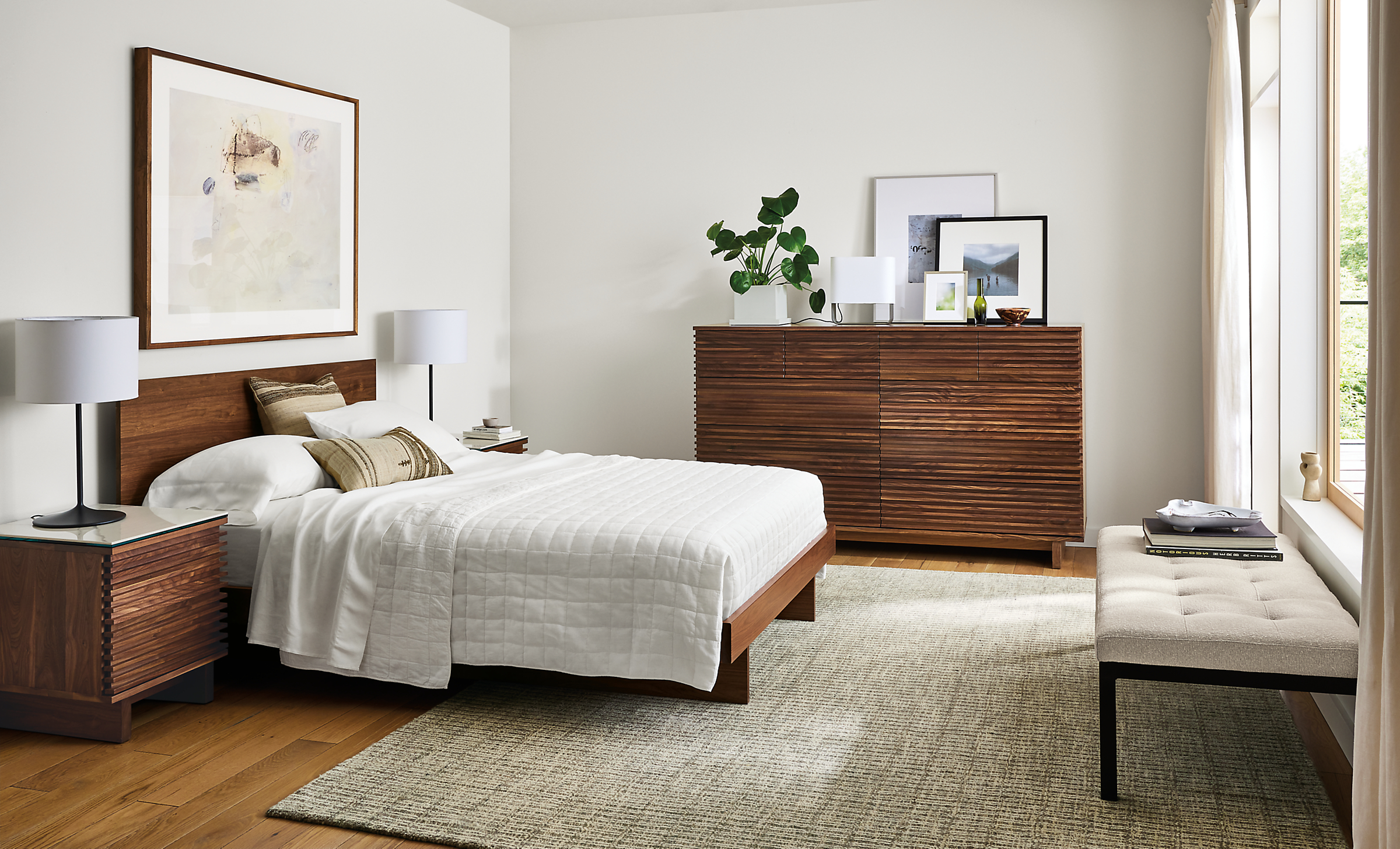 Bedroom with Coles ten-drawer dresser in walnut, Anton queen bed in walnut, and Nera 8 by 10 rug in stone.
