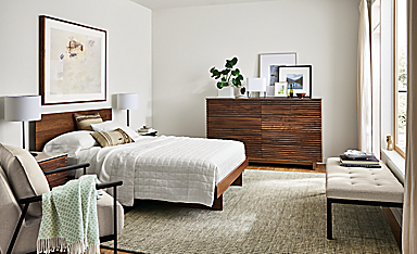 Bedroom with Anton queen bed in walnut and coles ten-drawer dresser in walnut with Nera rug in stone.