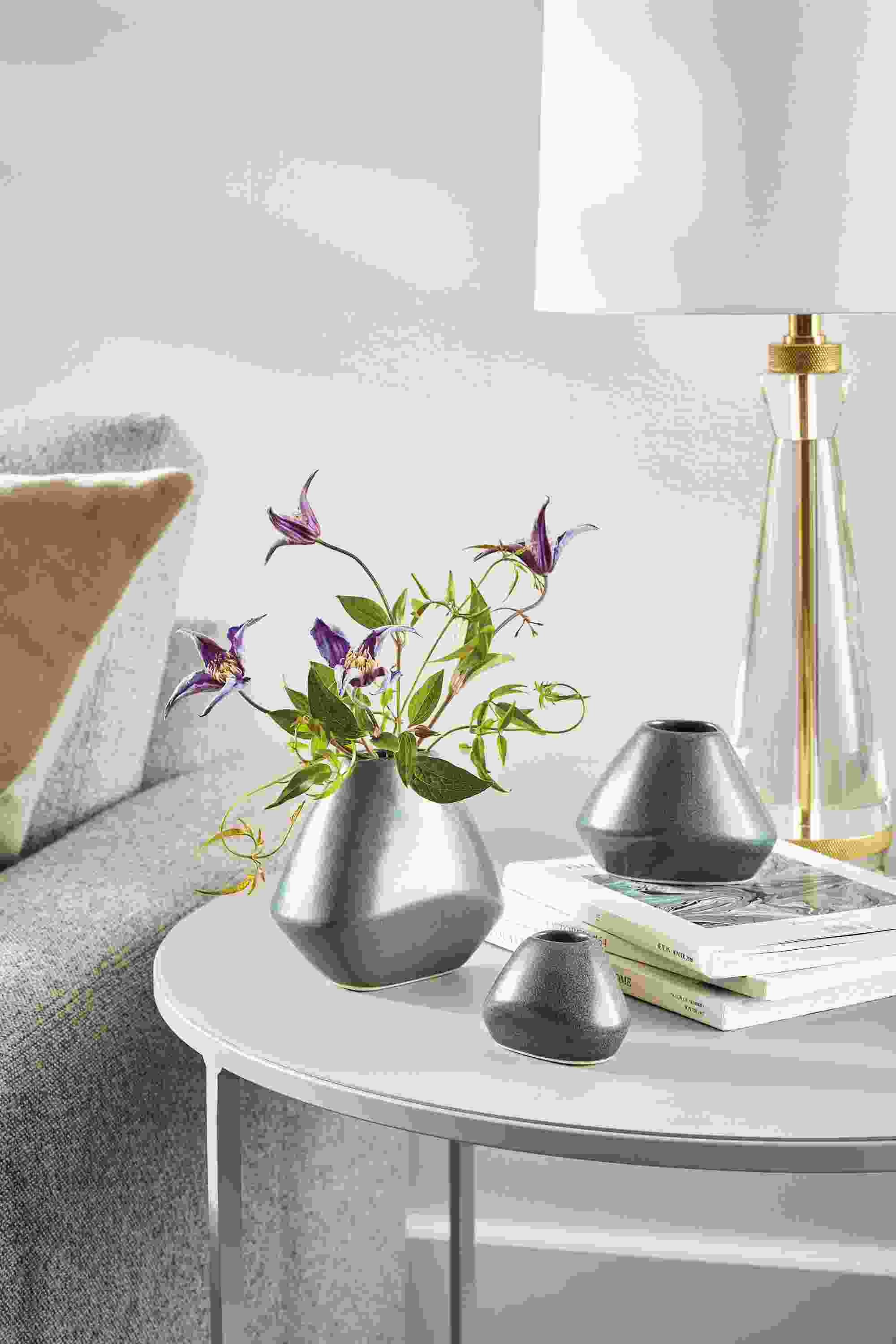 Slim round table with 3 Anya bud vases in Fern in a living room.