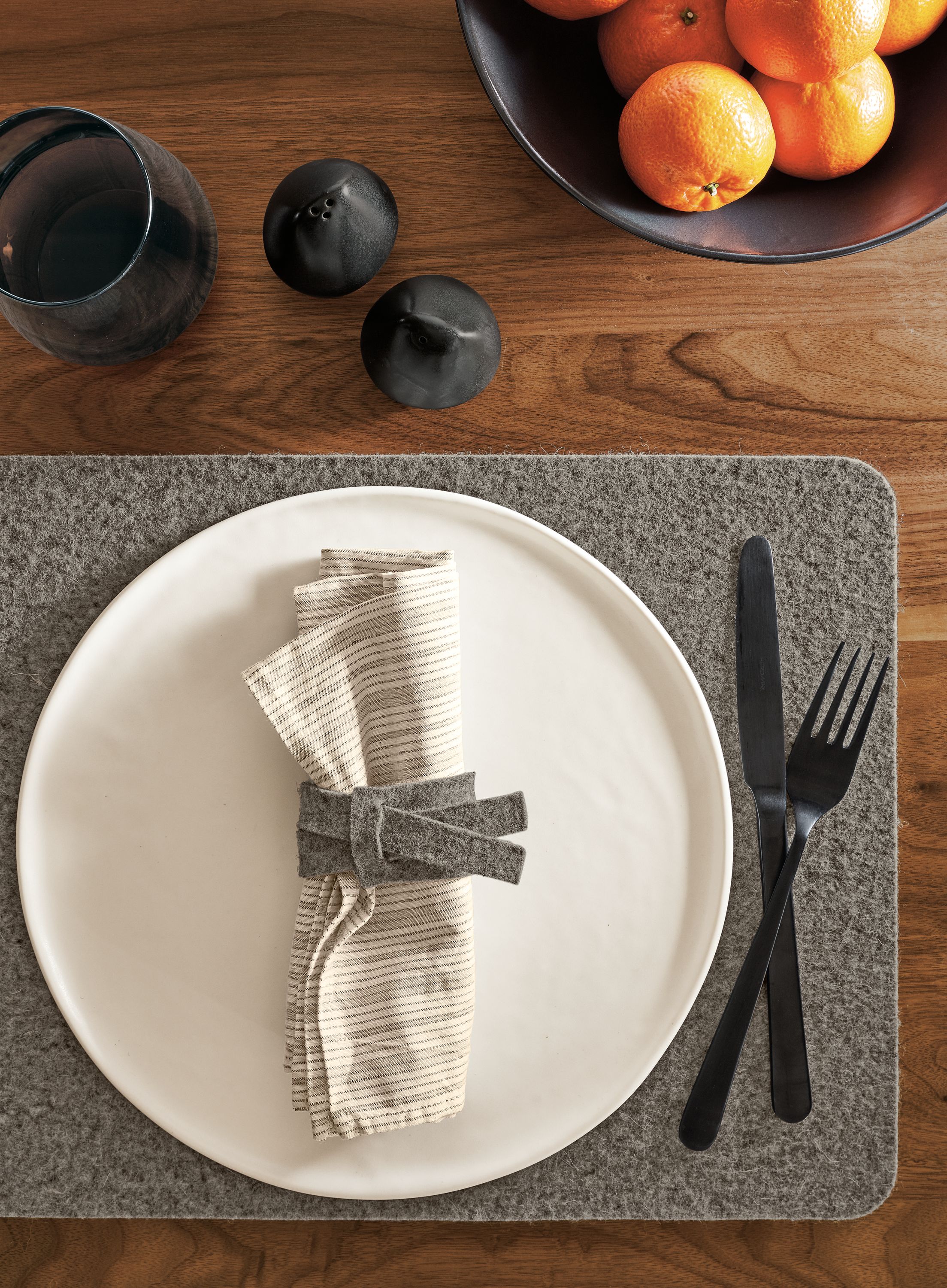 Detail of Verza felt napkin ring in place setting next to Anya bowl.